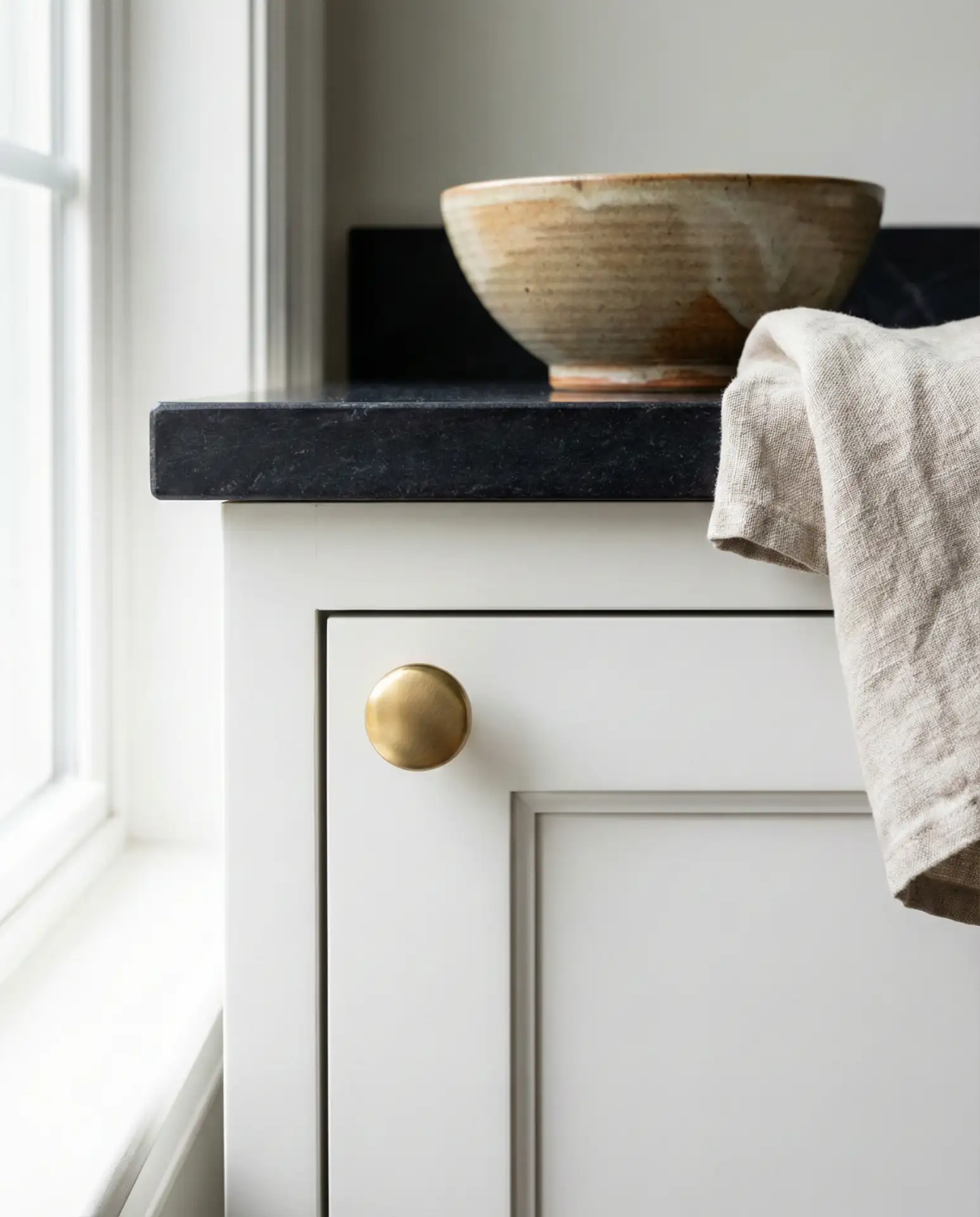 Warm White Cabinets with Black Countertops and Gold Hardware 2