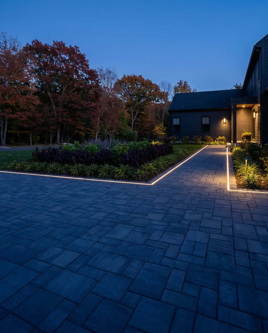Geometric Paver Driveway with Dark Hues and Accent Lighting