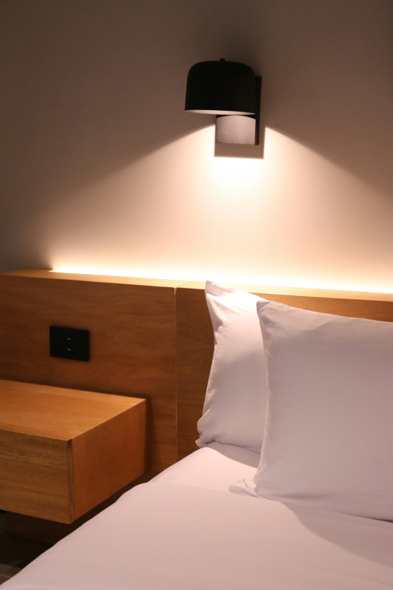 a bed with white sheets and pillows in a room