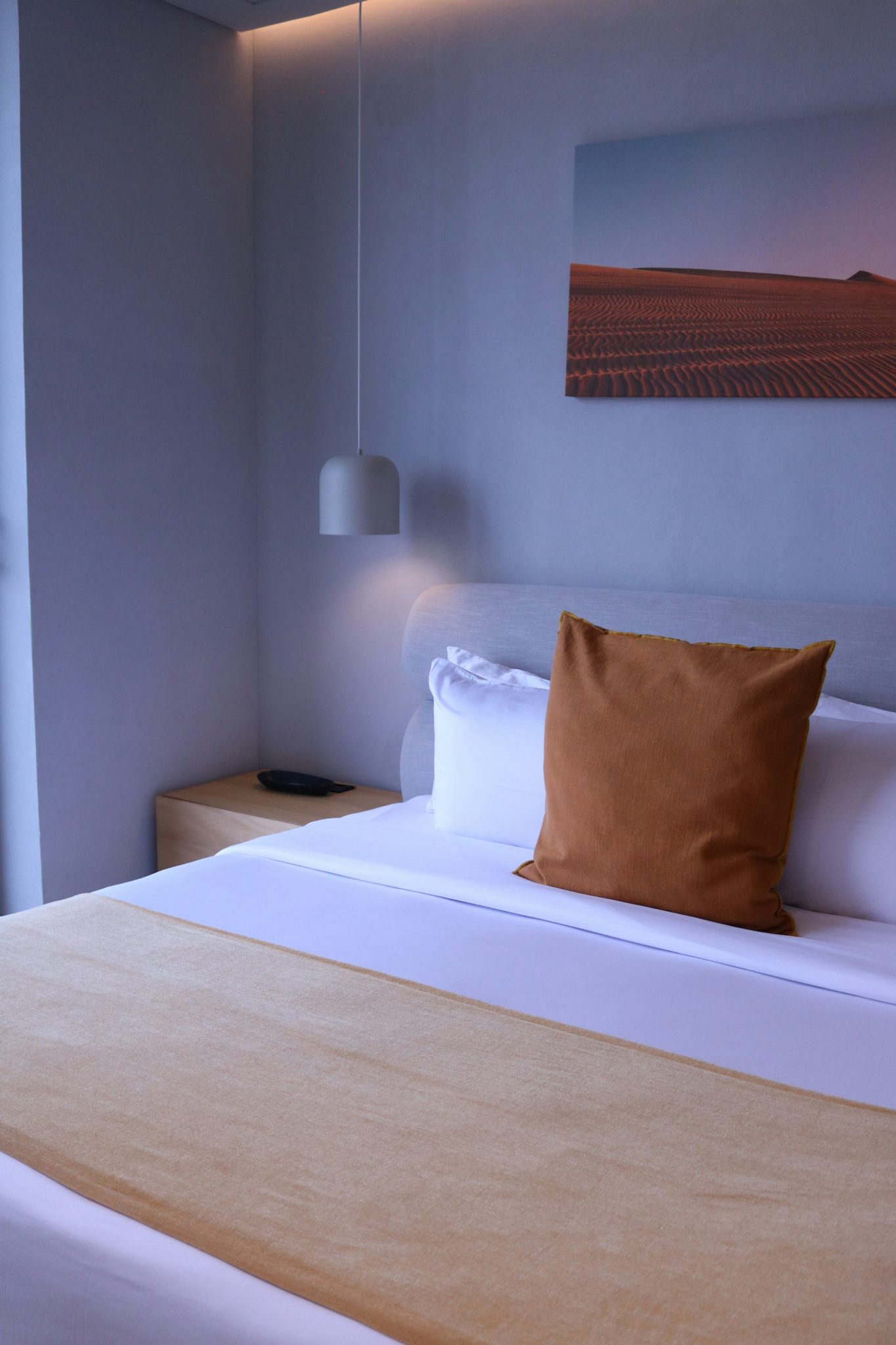 a bedroom with a bed and a painting on the wall