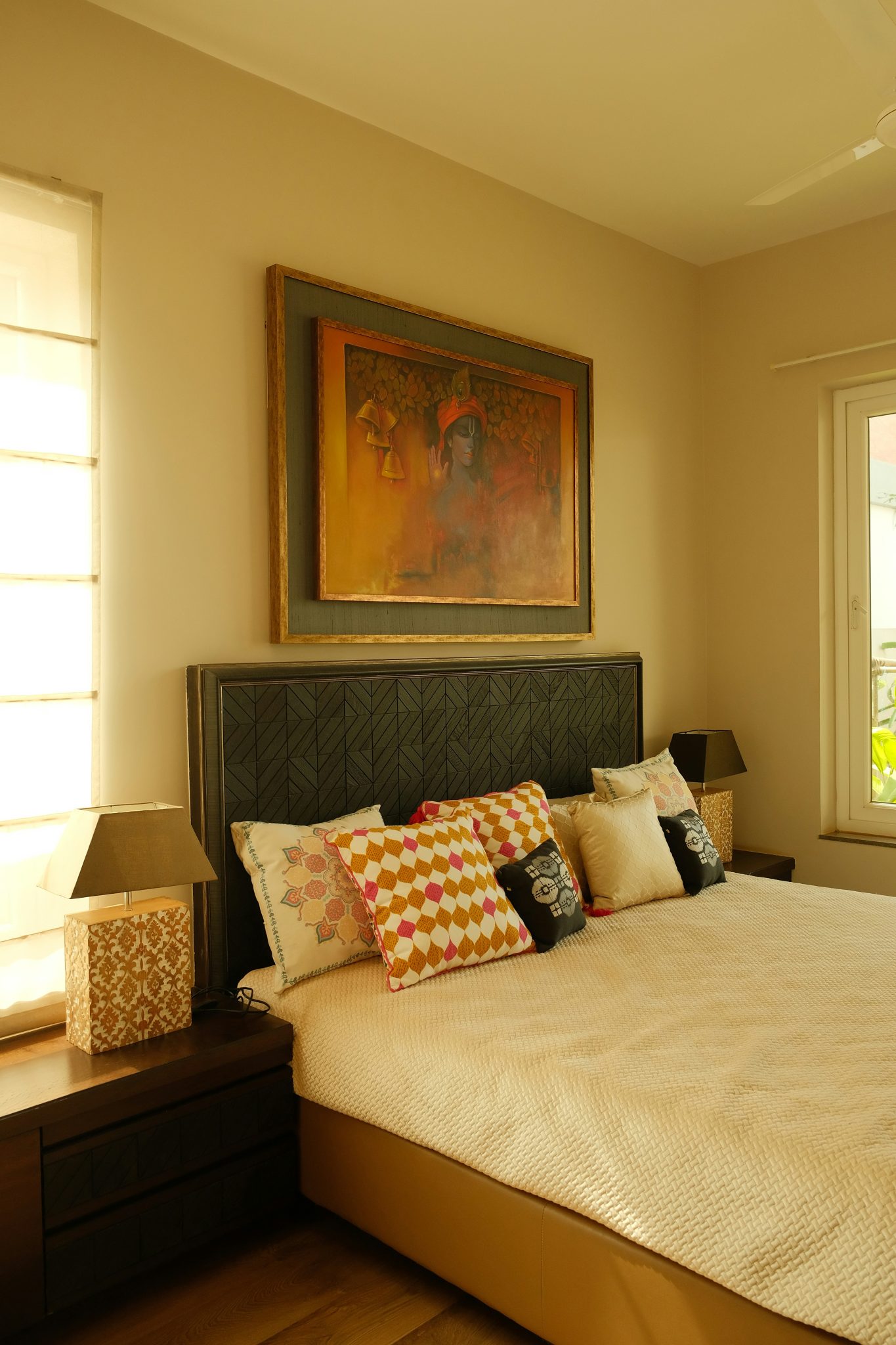 A bedroom with a large bed and a painting on the wall