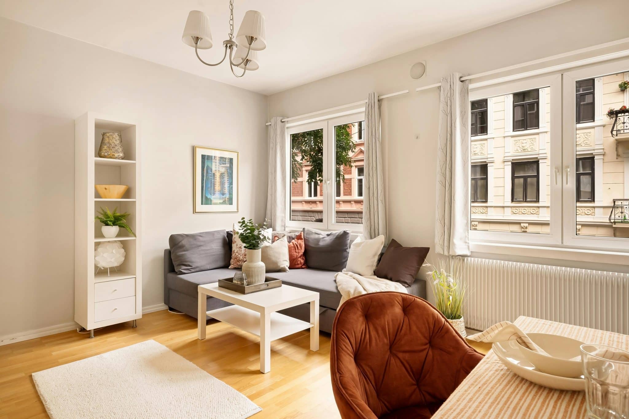 A bright and modern living room with stylish furniture and ample natural light through large windows.