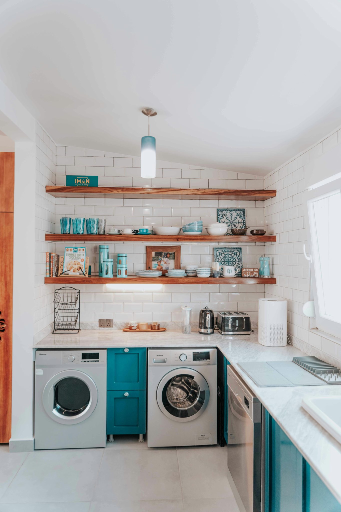 A bright modern kitchen featuring open shelving and integrated washing appliances.