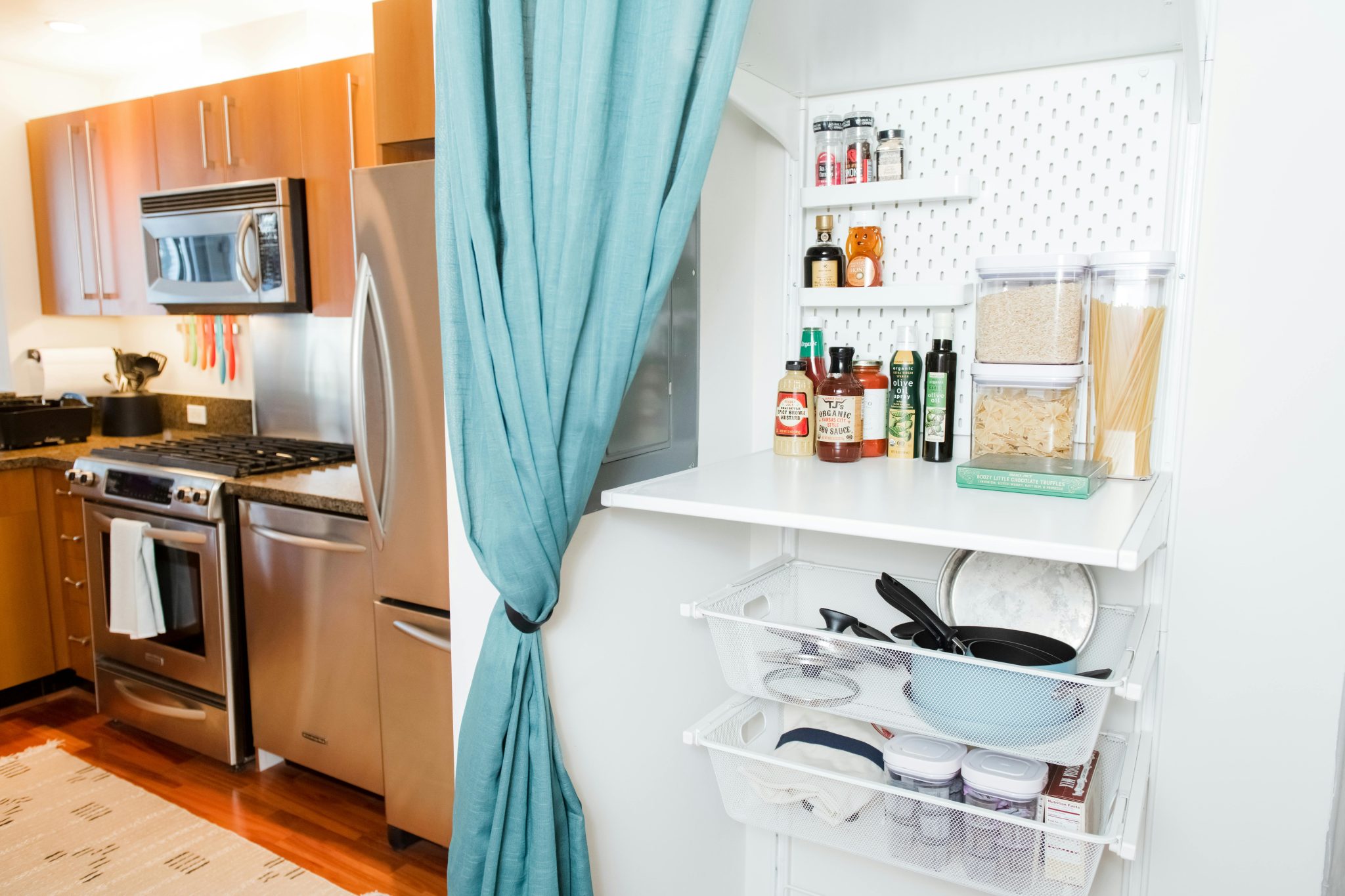 A contemporary kitchen featuring stainless steel appliances and a well-organized pantry.