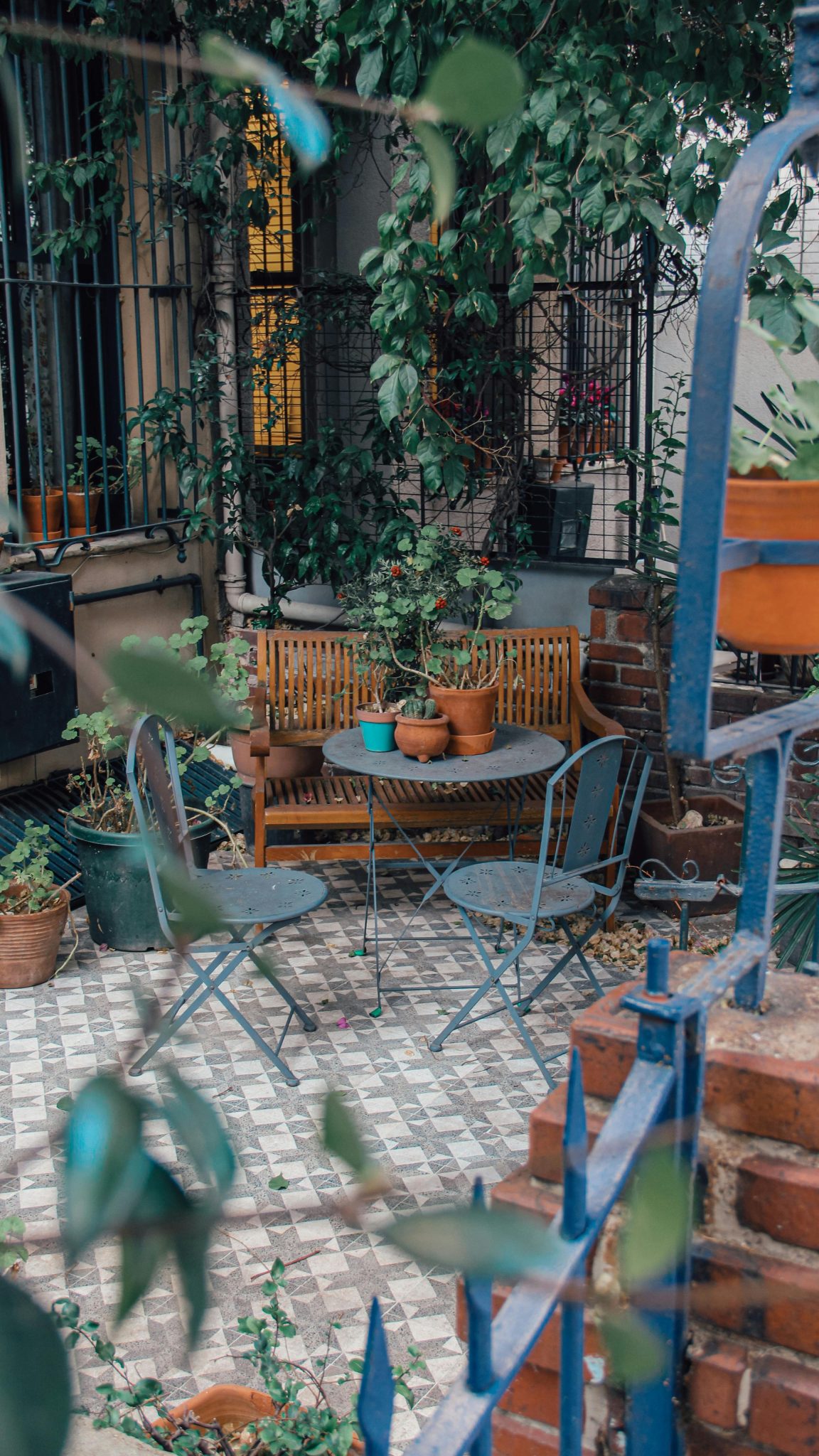 A cozy garden setting in Türkiye featuring chairs, a table, and rich greenery for a relaxing retreat.