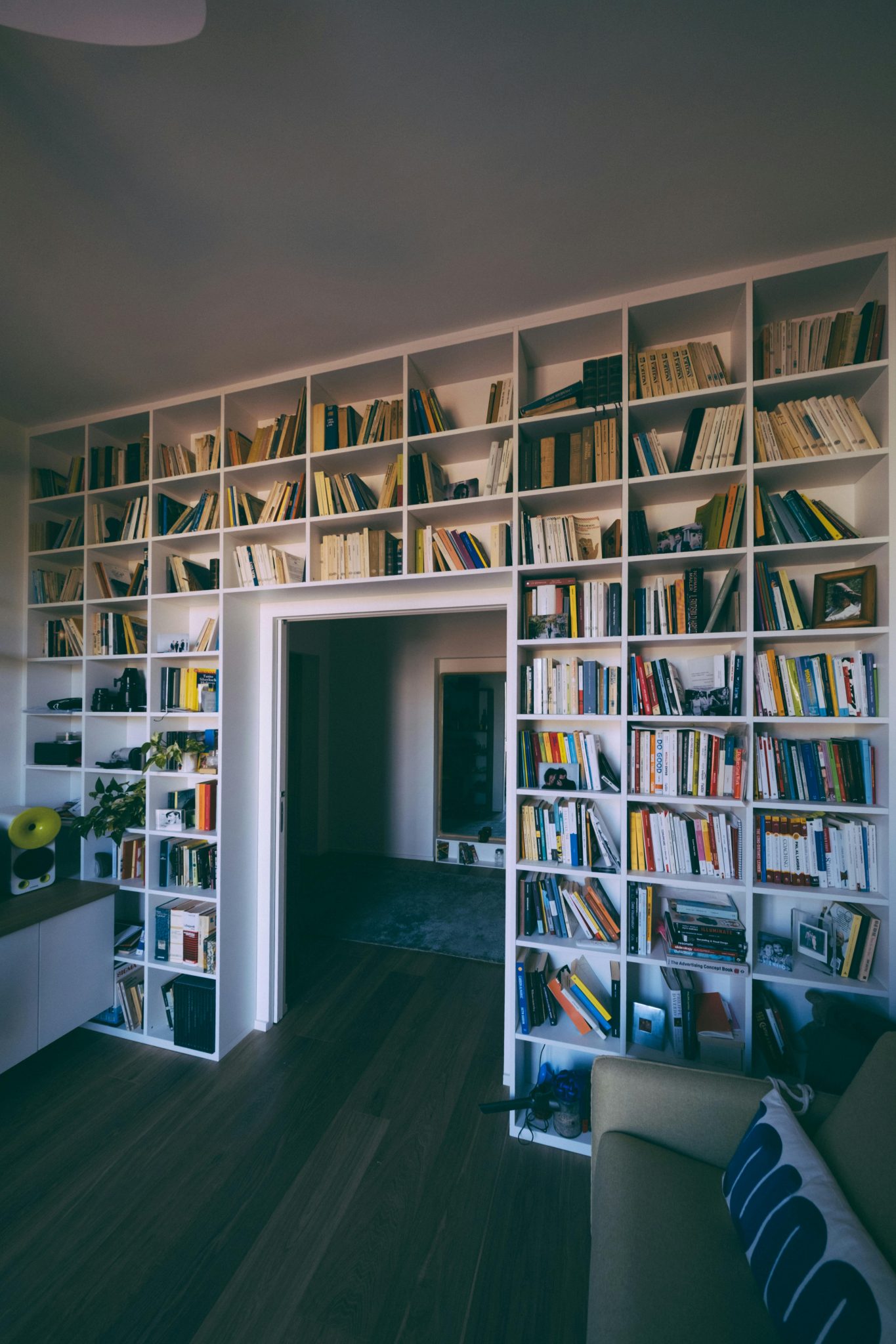A cozy indoor library with floor-to-ceiling bookshelves filled with books, creating a serene reading nook.
