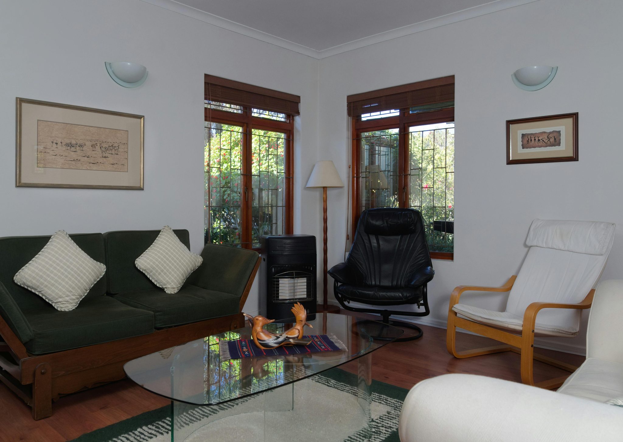 A cozy living room showcasing modern furniture with natural lighting from large windows.