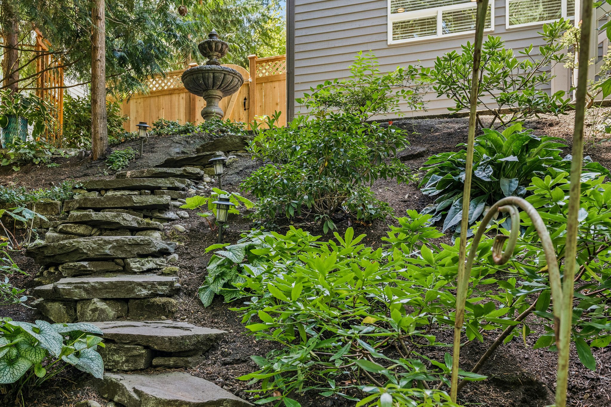 a garden with stone steps leading up to a house