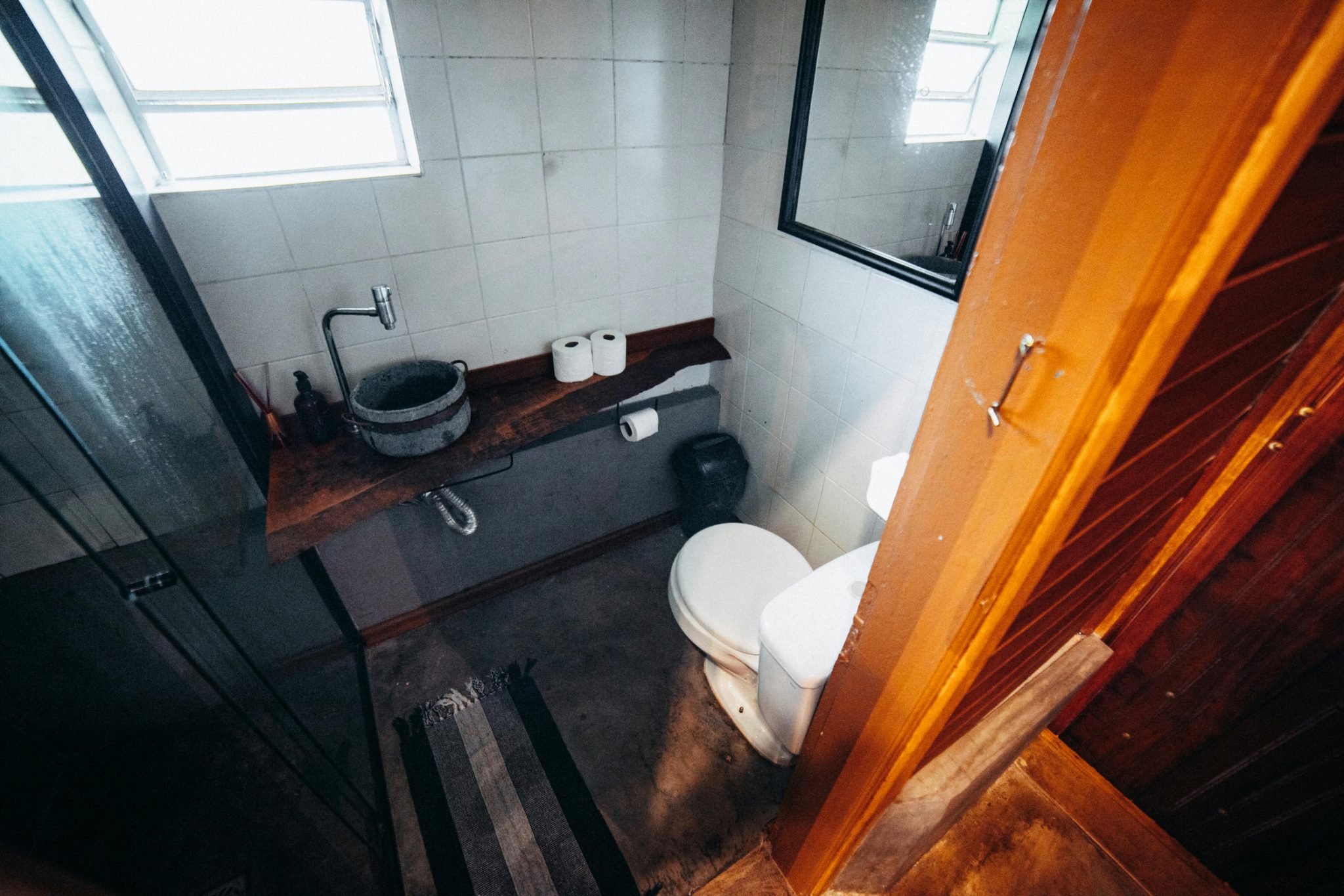 A modern minimalist bathroom featuring a unique stone basin and rustic wood elements, perfect for interior inspiration.