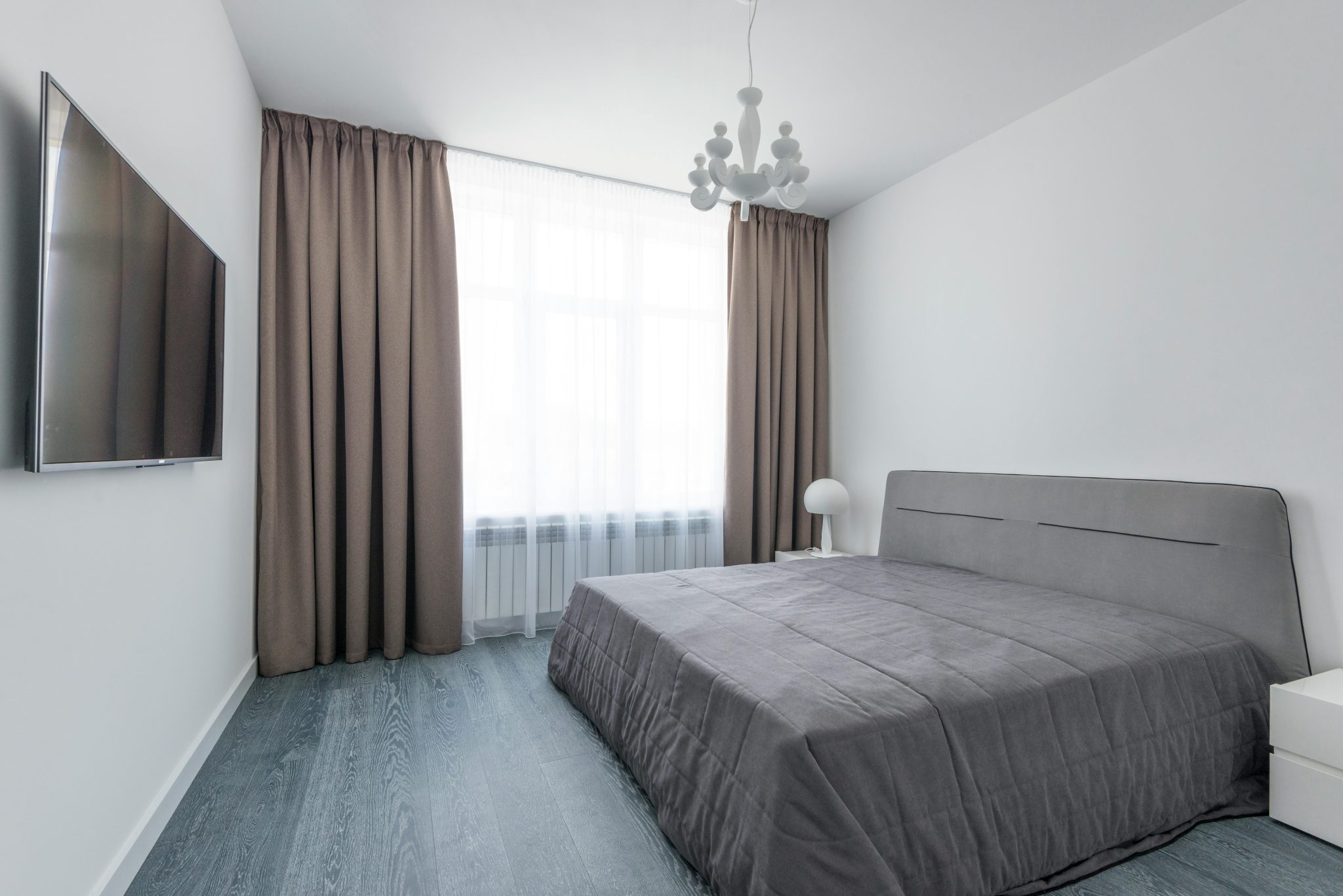 A sleek and modern minimalist bedroom featuring neutral tones and natural light.