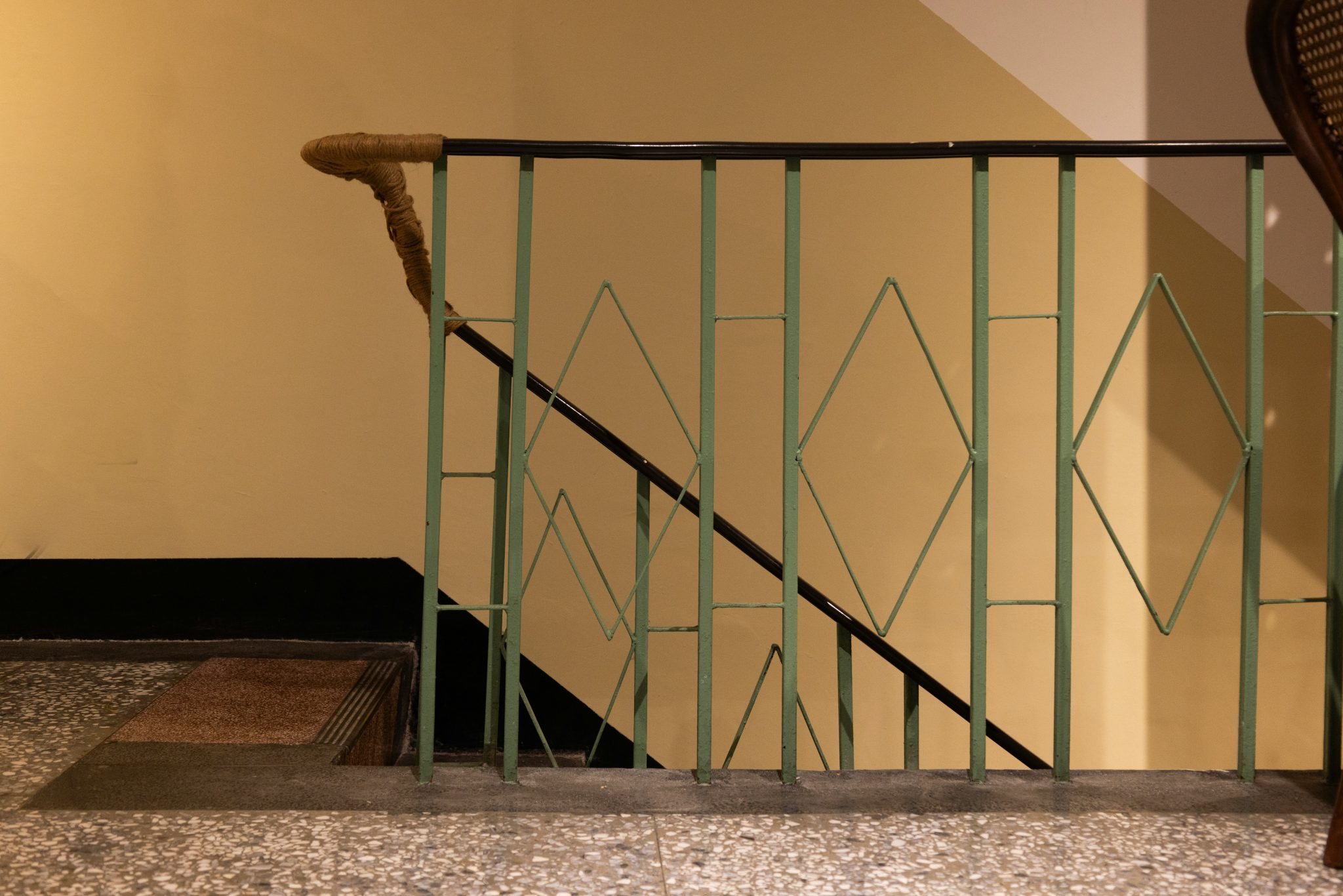 A staircase with a green metal railing