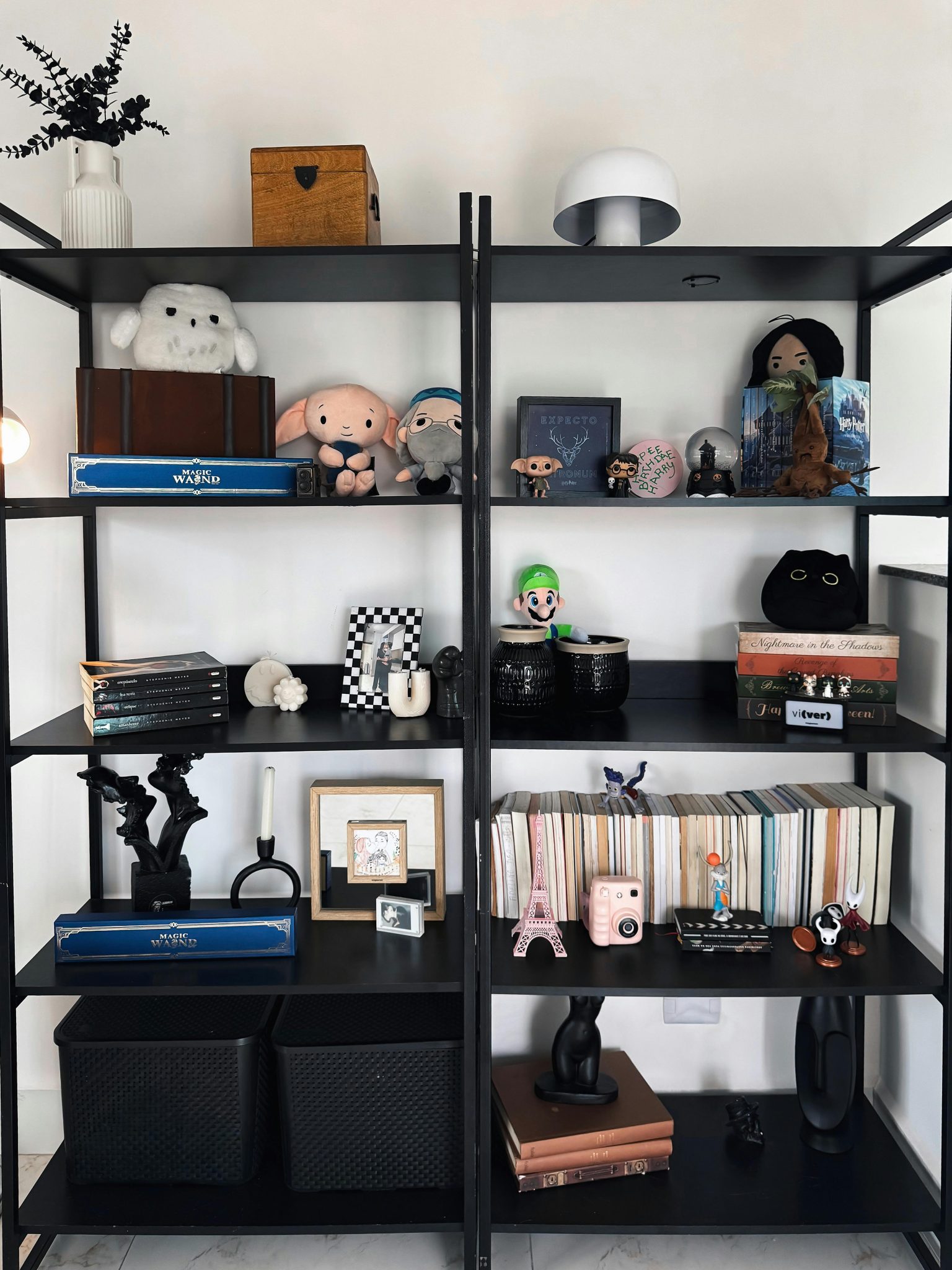 A stylish black bookshelf displaying a mix of plush toys, books, and unique decorative items.