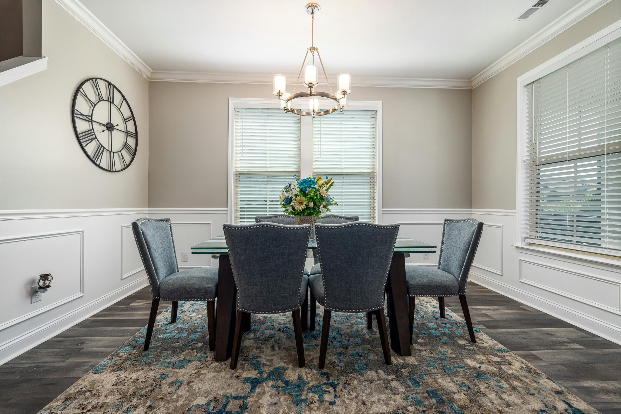 A stylish dining room featuring a glass table, upholstered chairs, and contemporary decor.
