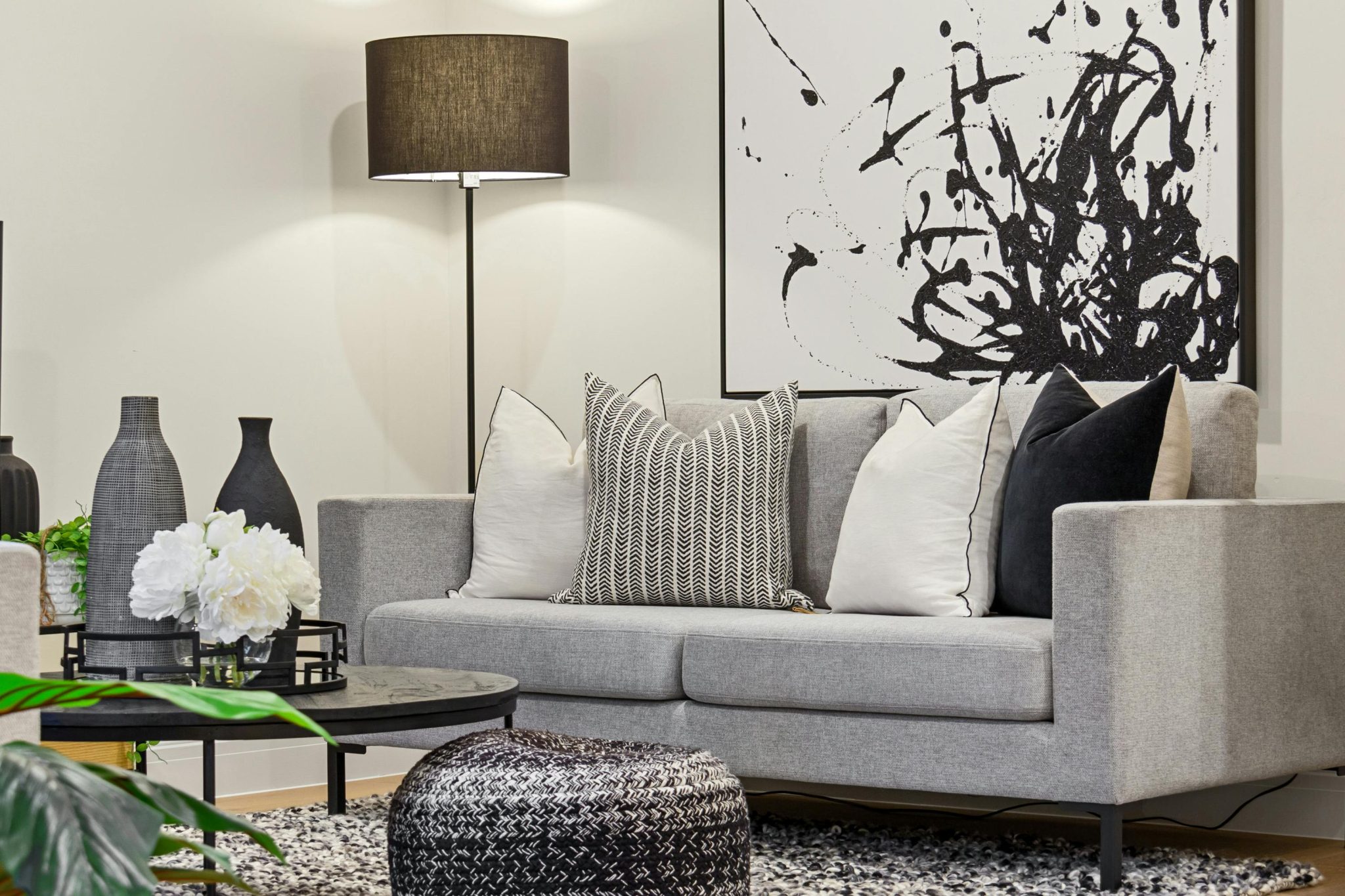 A stylish grey living room featuring abstract artwork, a modern couch, and elegant decor.