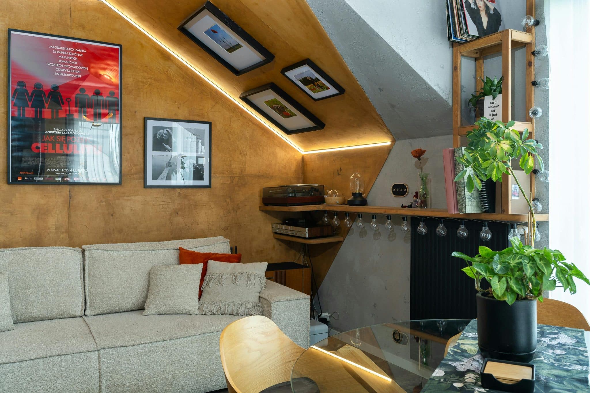 A stylish modern living room featuring plants, artwork, and warm lighting.