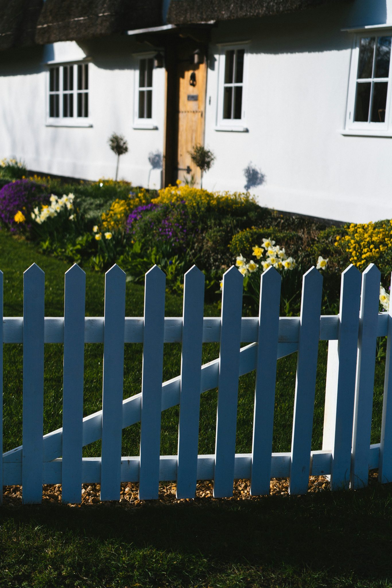 a white picket fence in front of a white house