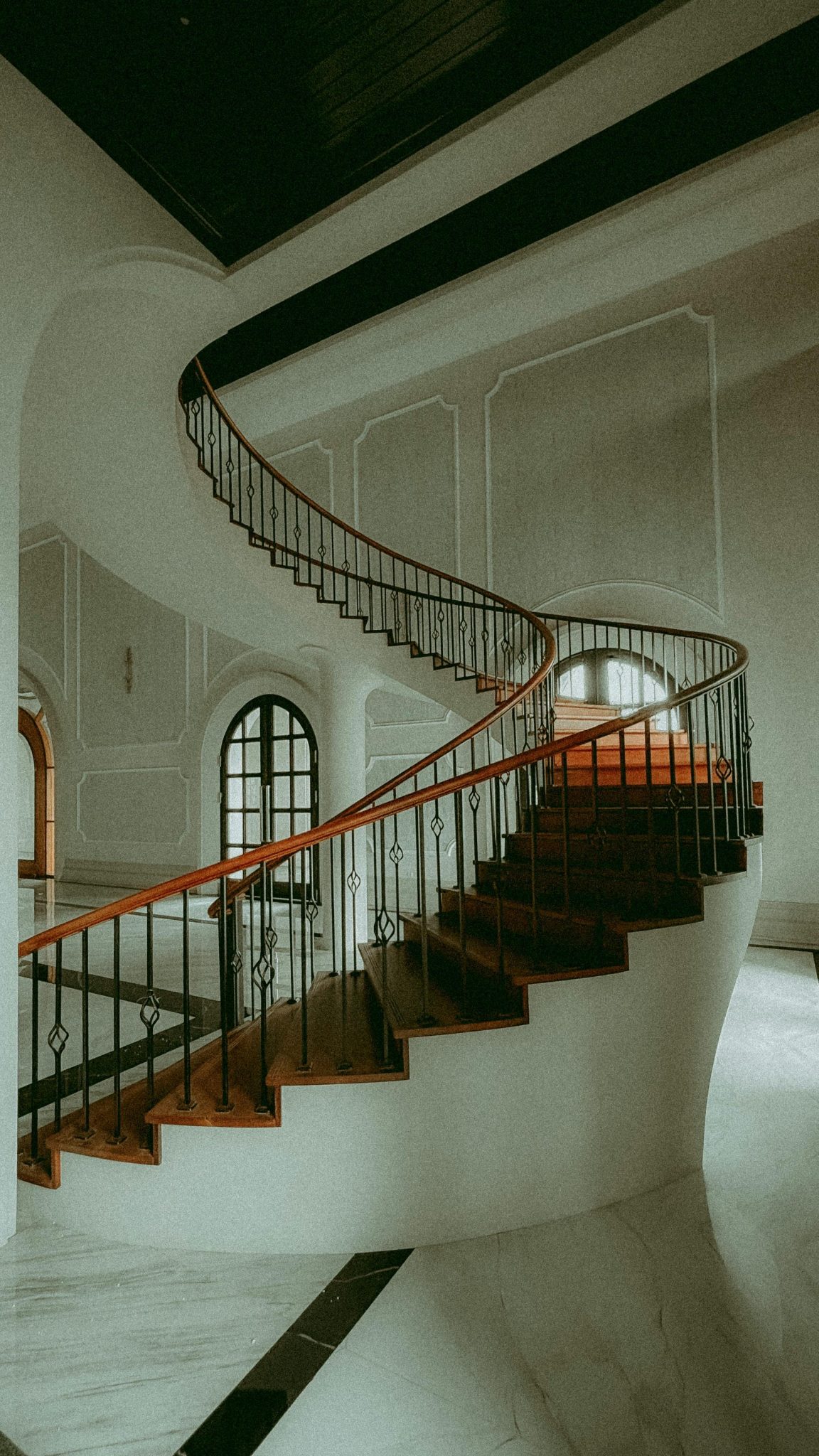 An artistic view of a spiral staircase in a classic interior, highlighting elegant architecture.