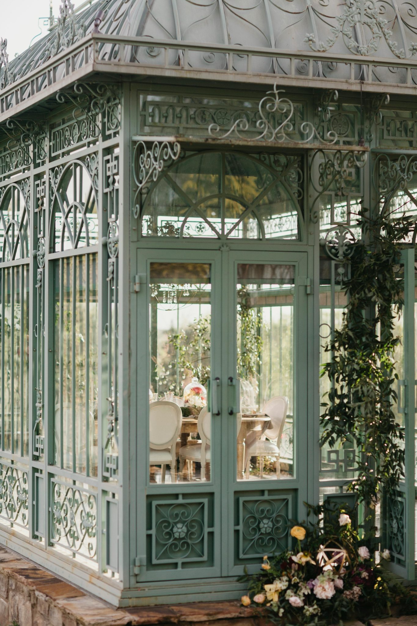 Beautiful glass sunroom adorned with intricate design and flowers.