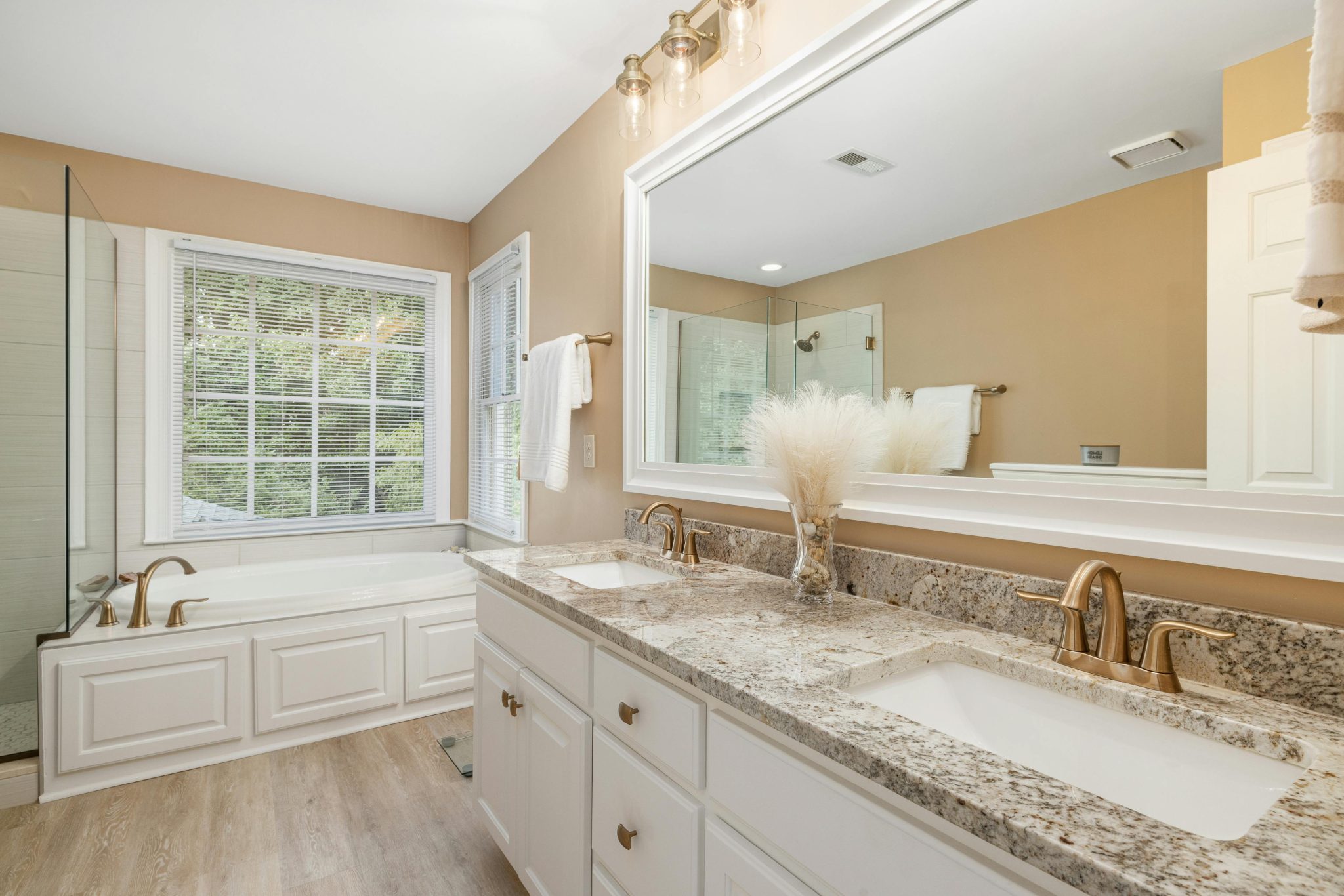 Bright and spacious bathroom featuring granite countertops and stylish fixtures.