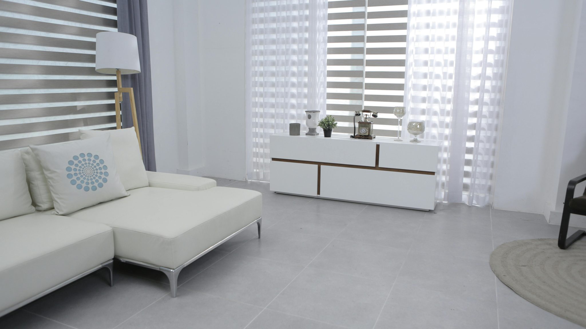 Bright and spacious living room featuring modern minimalist decor, a white sofa, and sleek furniture.