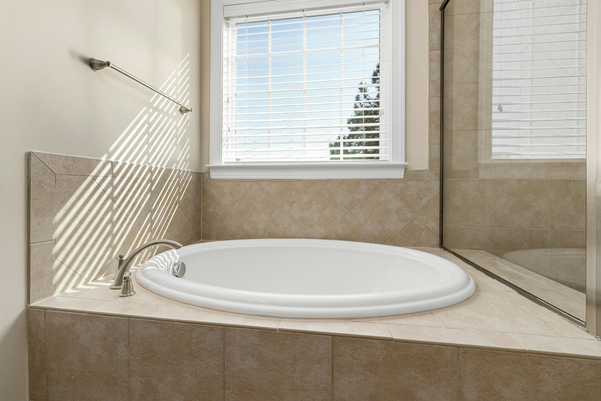 Bright bathroom interior featuring a stylish white bathtub and tiled design.
