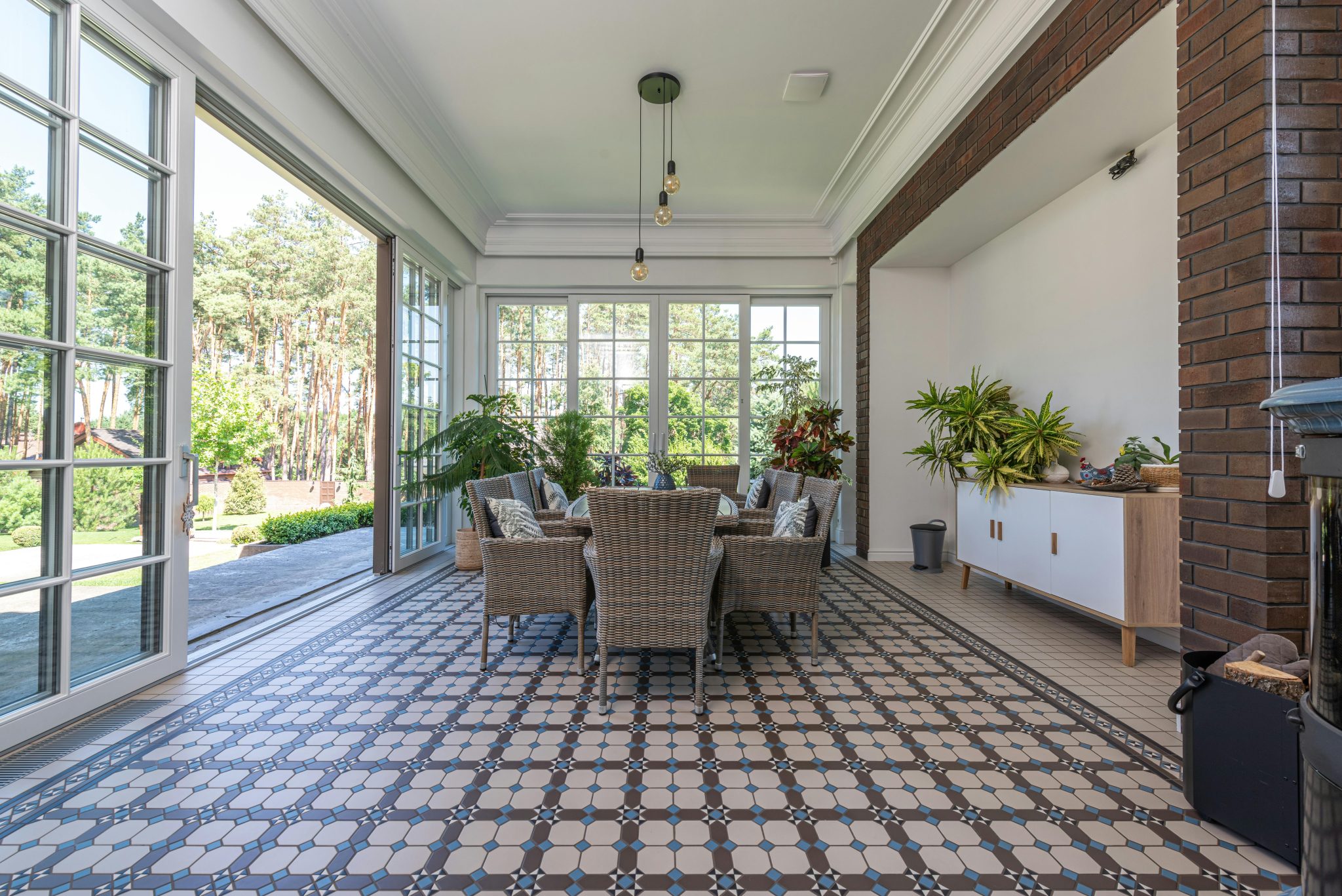 Bright sunroom with wicker chairs and patterned tile floor, ideal for relaxation.