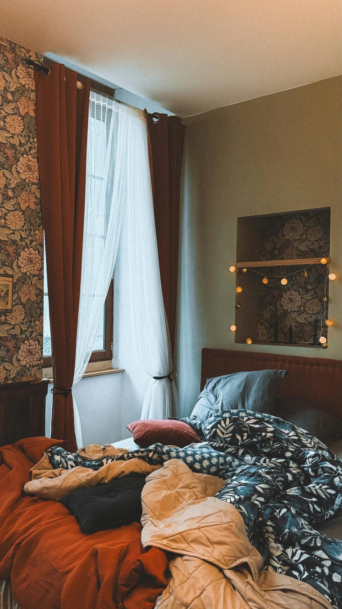 Charming bedroom scene with unmade bed and soft lighting creating an inviting atmosphere.