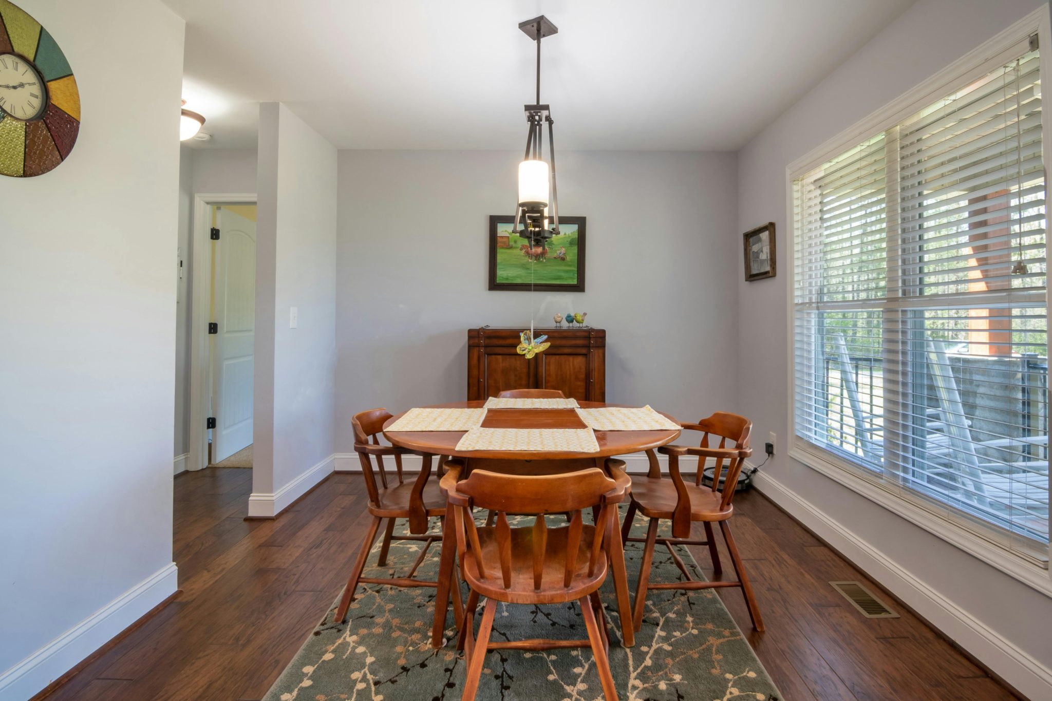 Charming dining room featuring wooden table and chairs, complemented by white walls and abundant natural light.