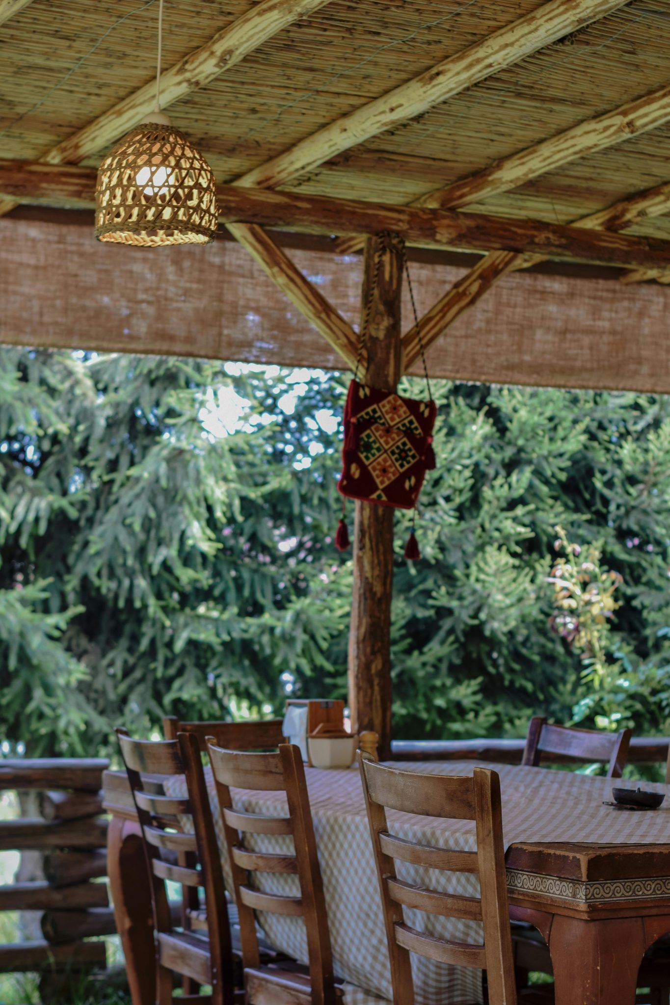 Charming outdoor dining setup with wooden chairs and natural decor, ideal for summer relaxation.