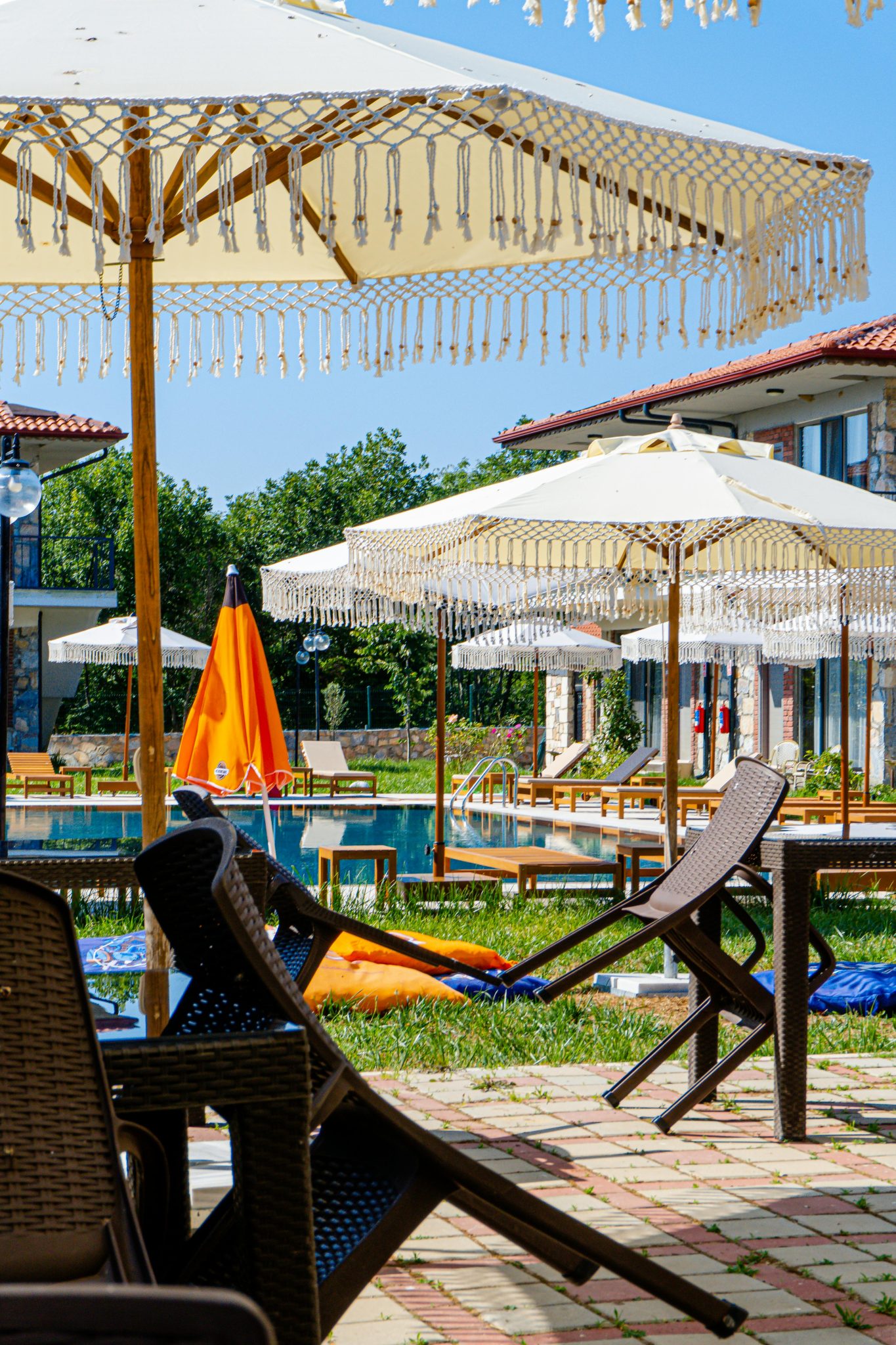 Charming poolside view with decorative sun umbrellas and lounge chairs on a sunny day.