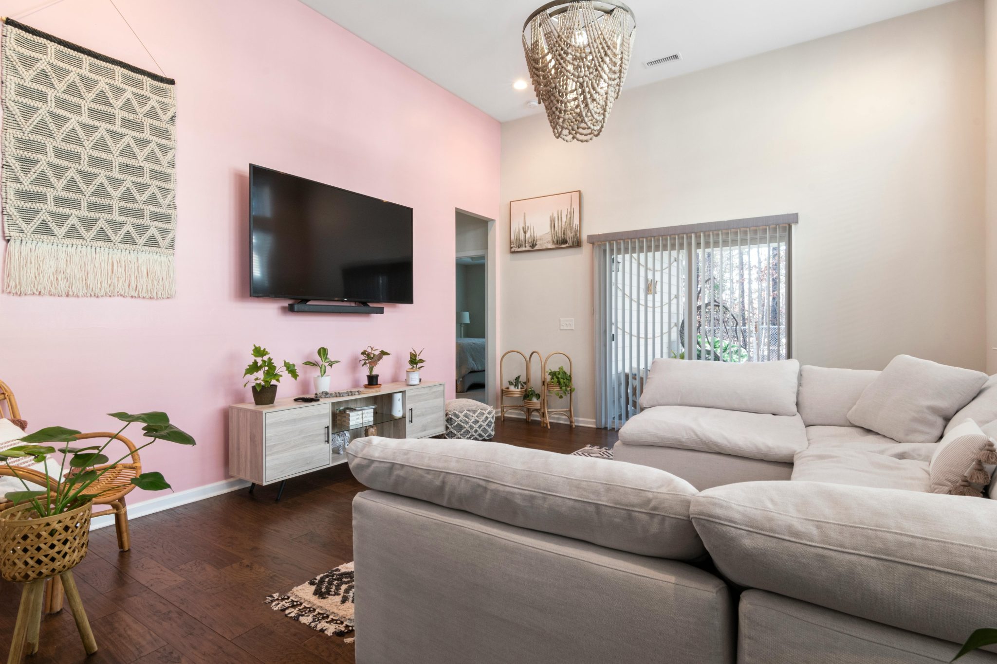 Chic living room featuring a pink accent wall, comfortable couch, and contemporary decor elements.