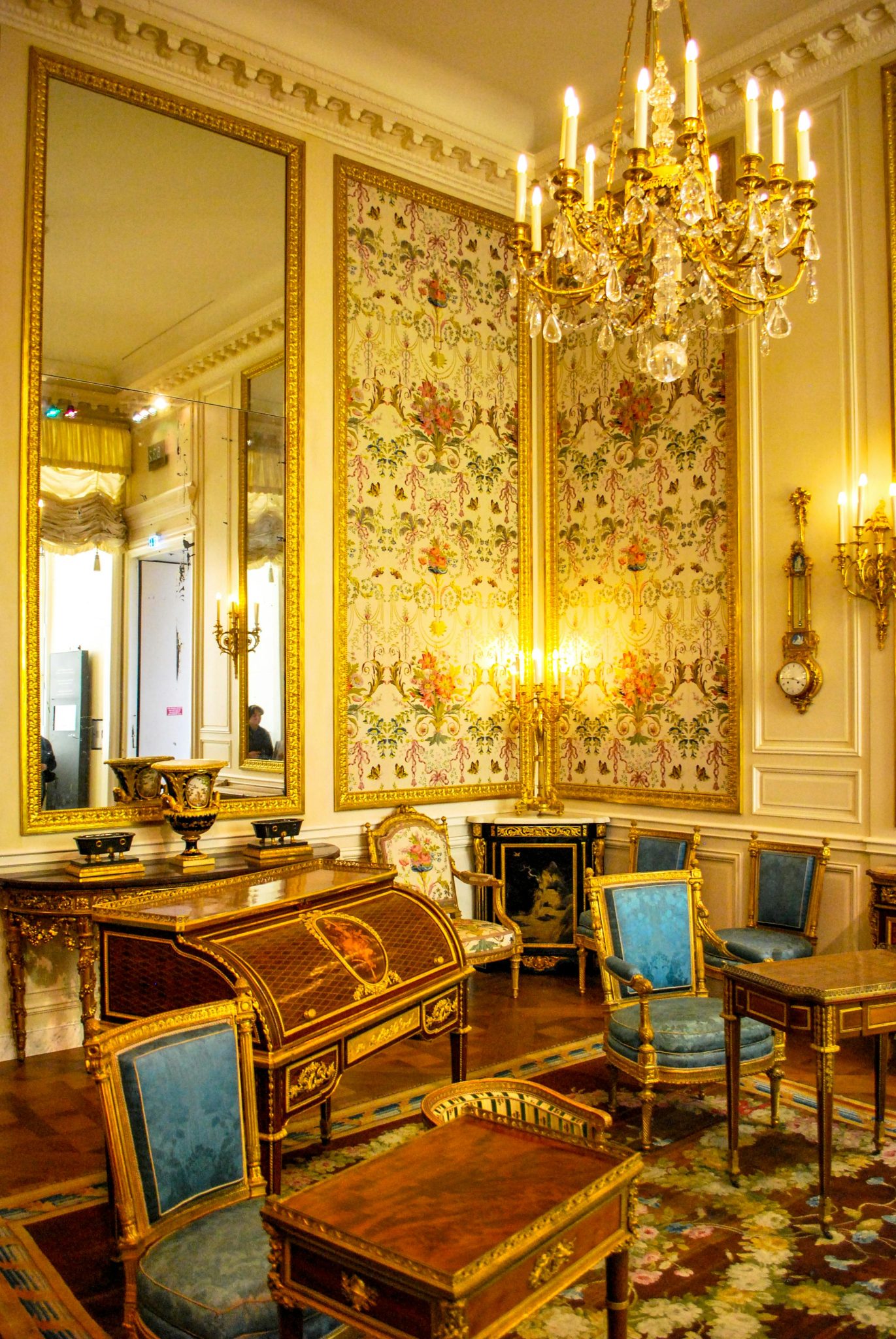 Classic Parisian salon featuring luxurious antique furniture and ornate chandeliers.