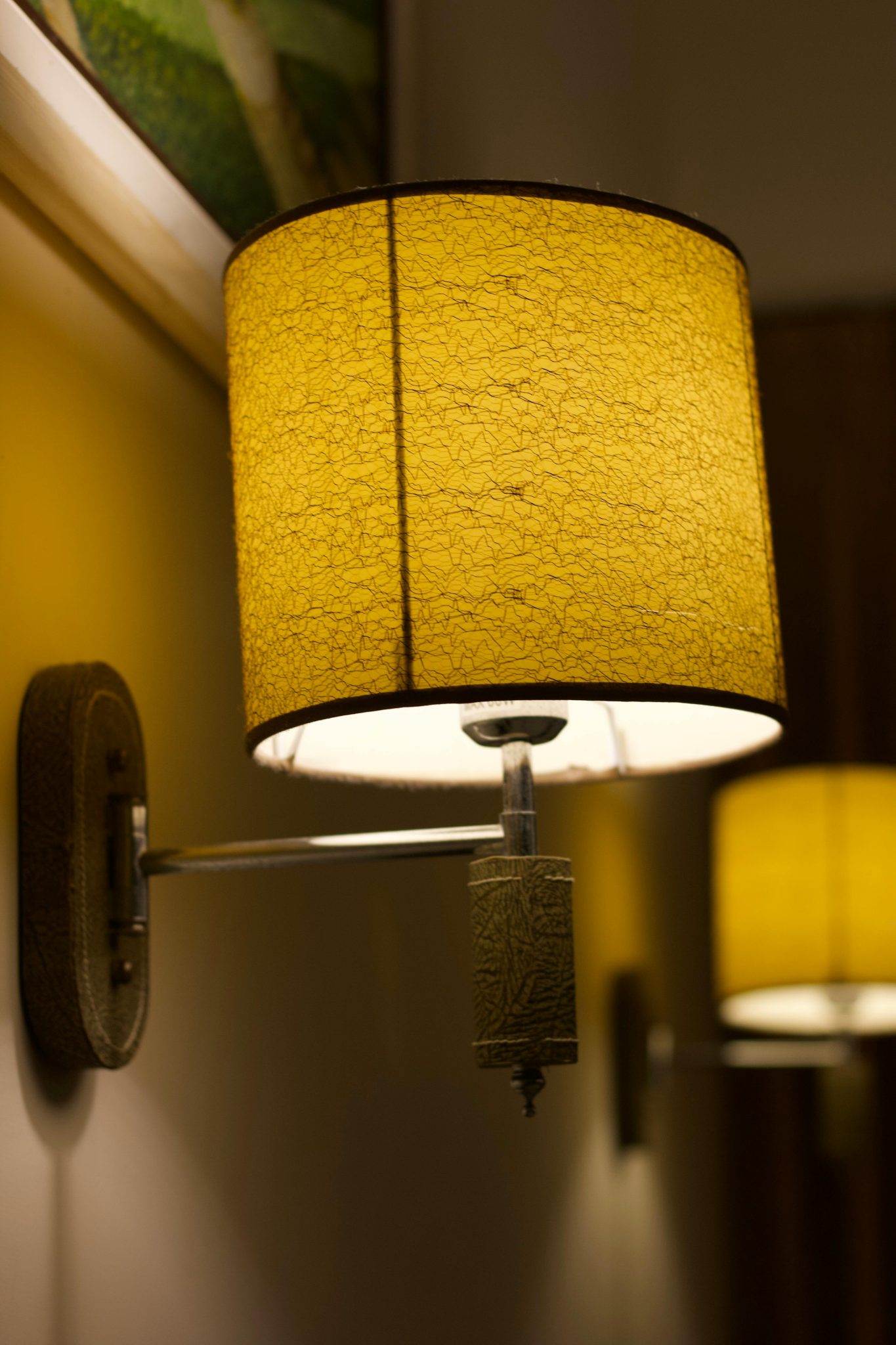 Close-up of a yellow wall lamp casting warm and cozy light indoors.