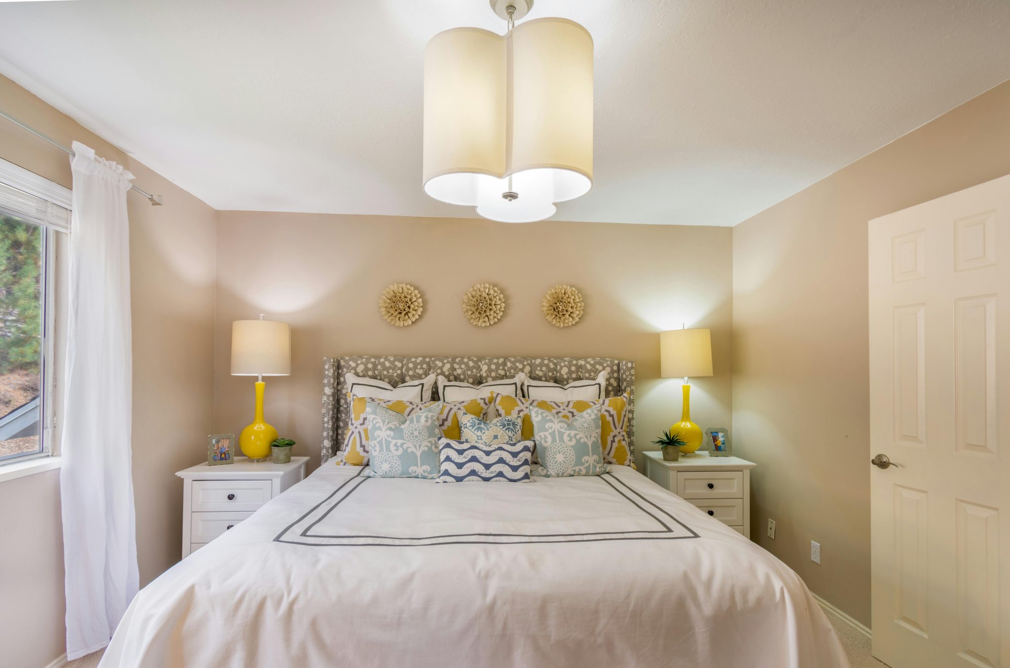 Comfortable bedroom featuring warm tones and stylish interior design with ample lighting.
