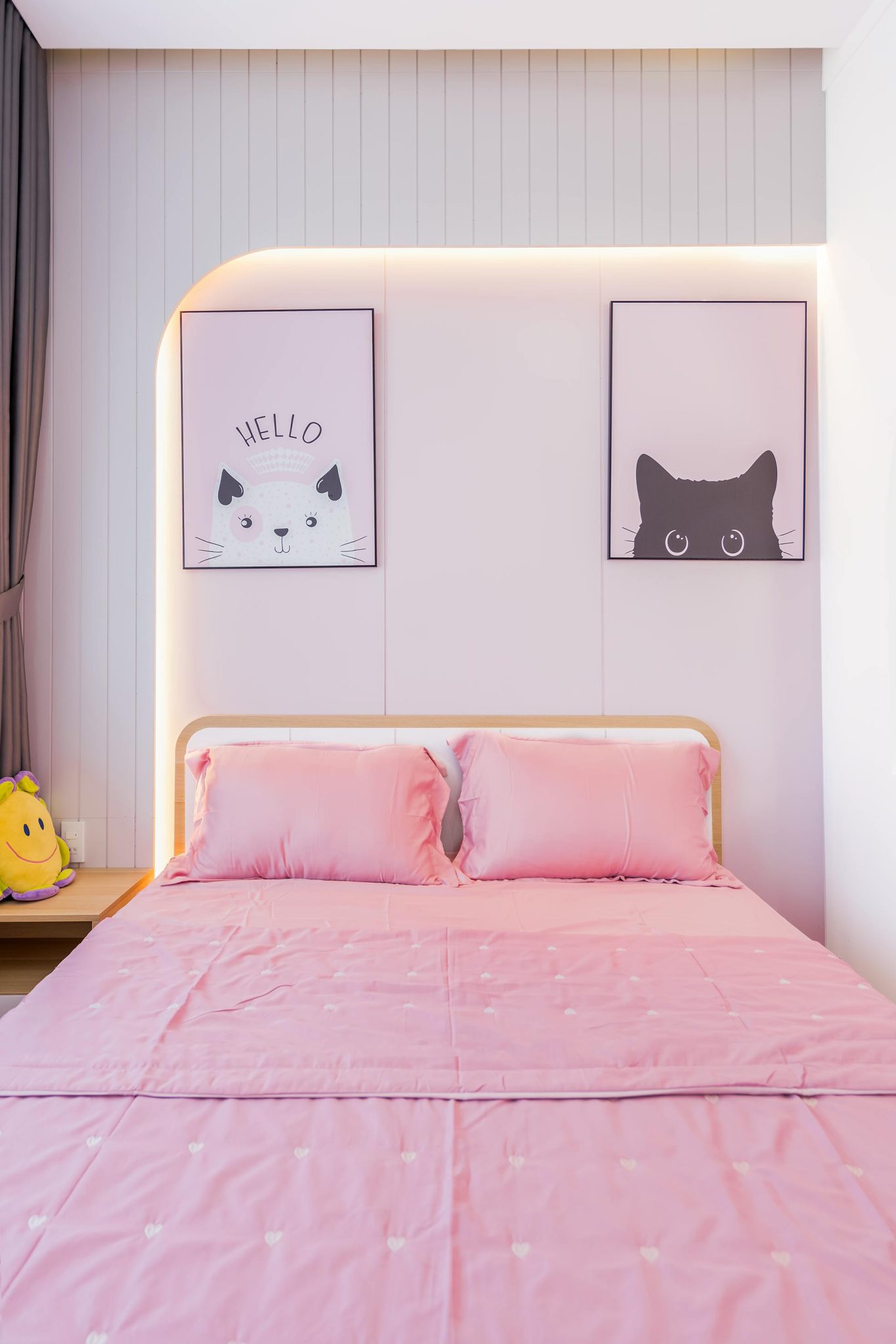 Contemporary room featuring pink beddings and cat-themed art.