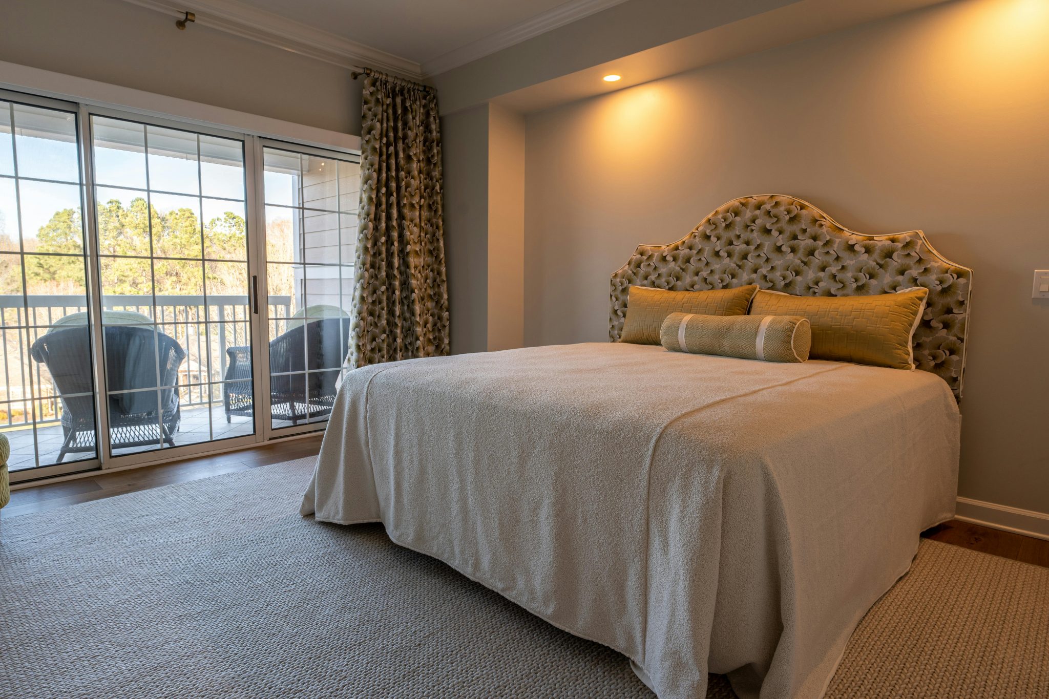 Cozy bedroom featuring elegant decor and a balcony view, perfect for relaxation.