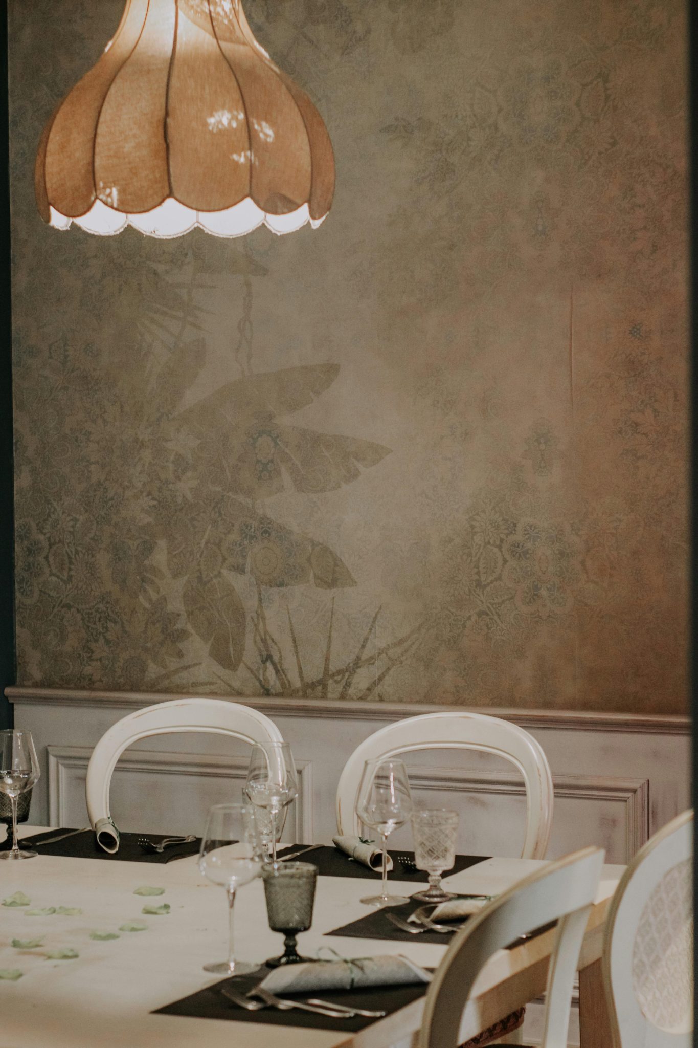Cozy dining setting with elegant table arrangement under a vintage chandelier.