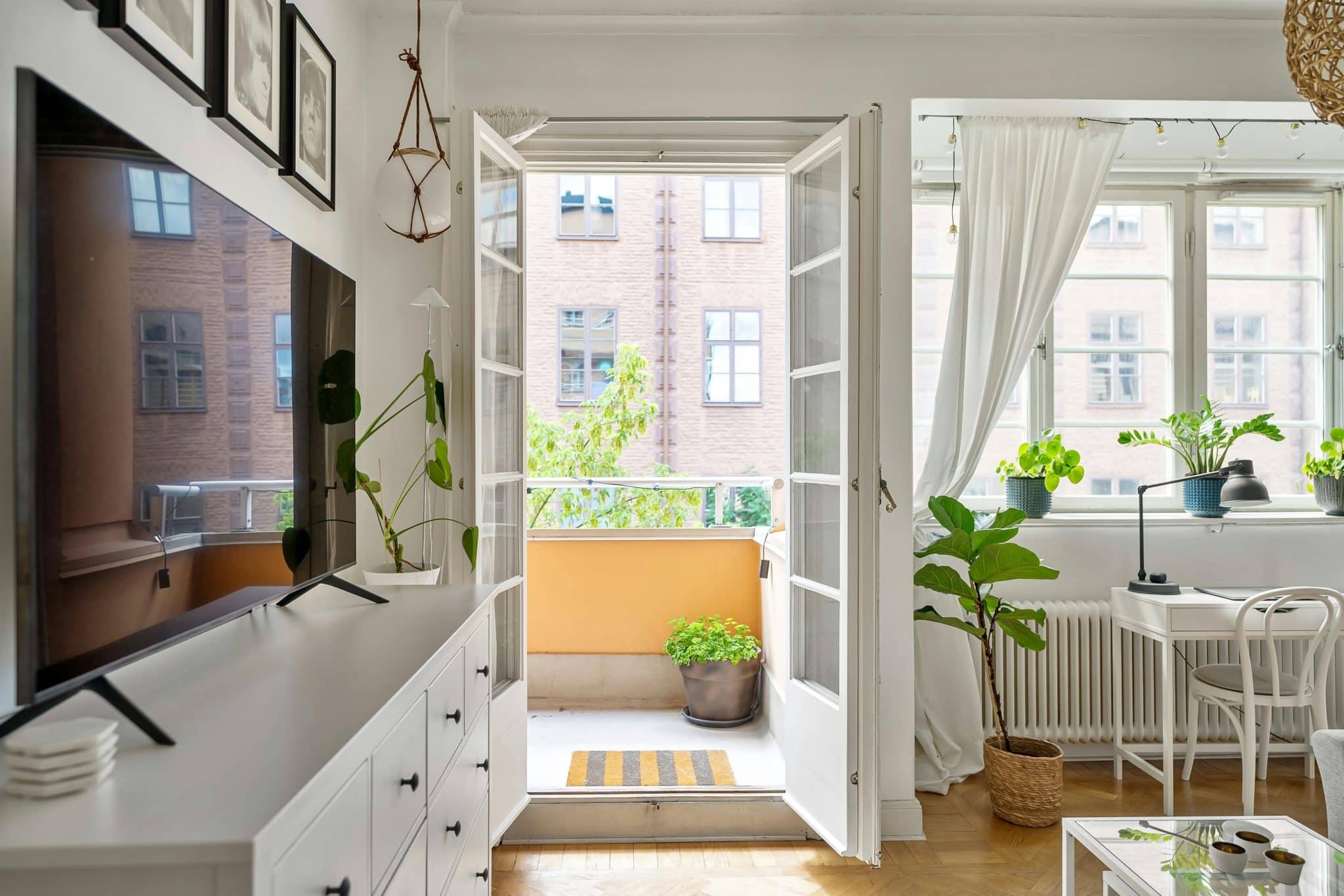 Cozy Scandinavian-style living room with a sunlit balcony and modern decor.