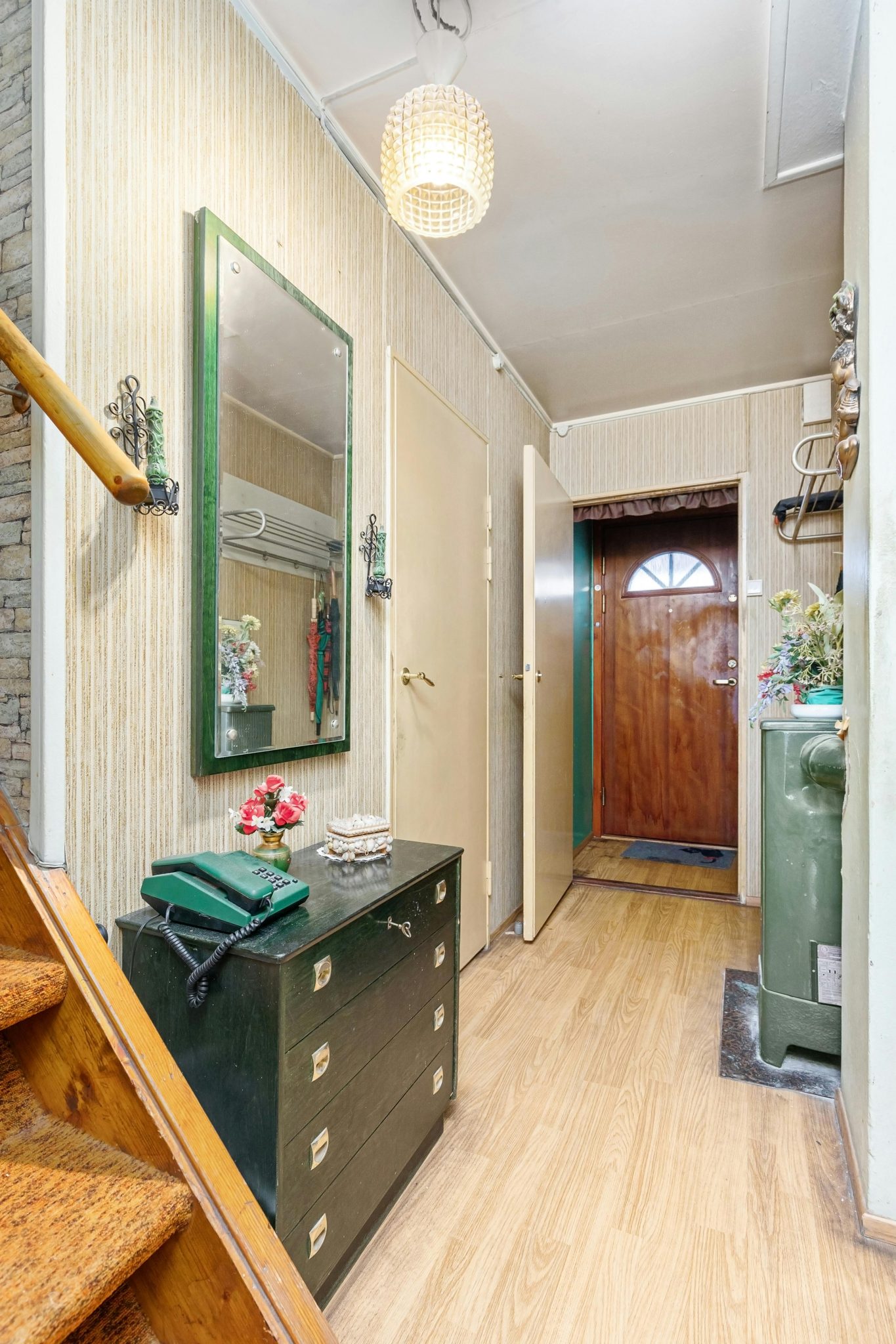 Cozy vintage home corridor featuring a mirror, dresser, and wooden elements.