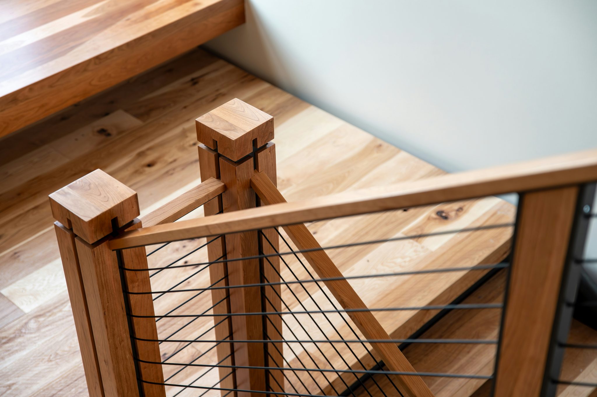 Custom interior black cable railing with cherry wood.