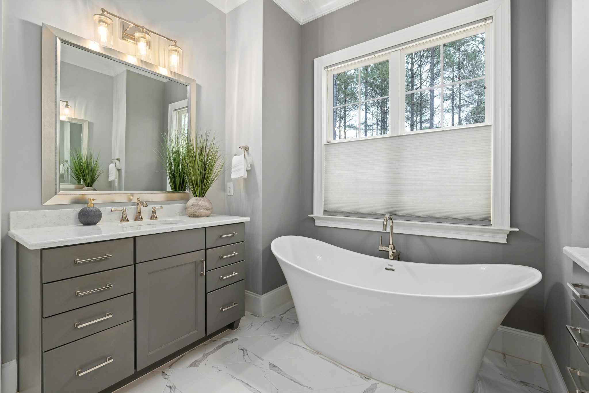 Elegant bathroom with a freestanding tub and stylish vanity featuring a mirror and modern lighting.