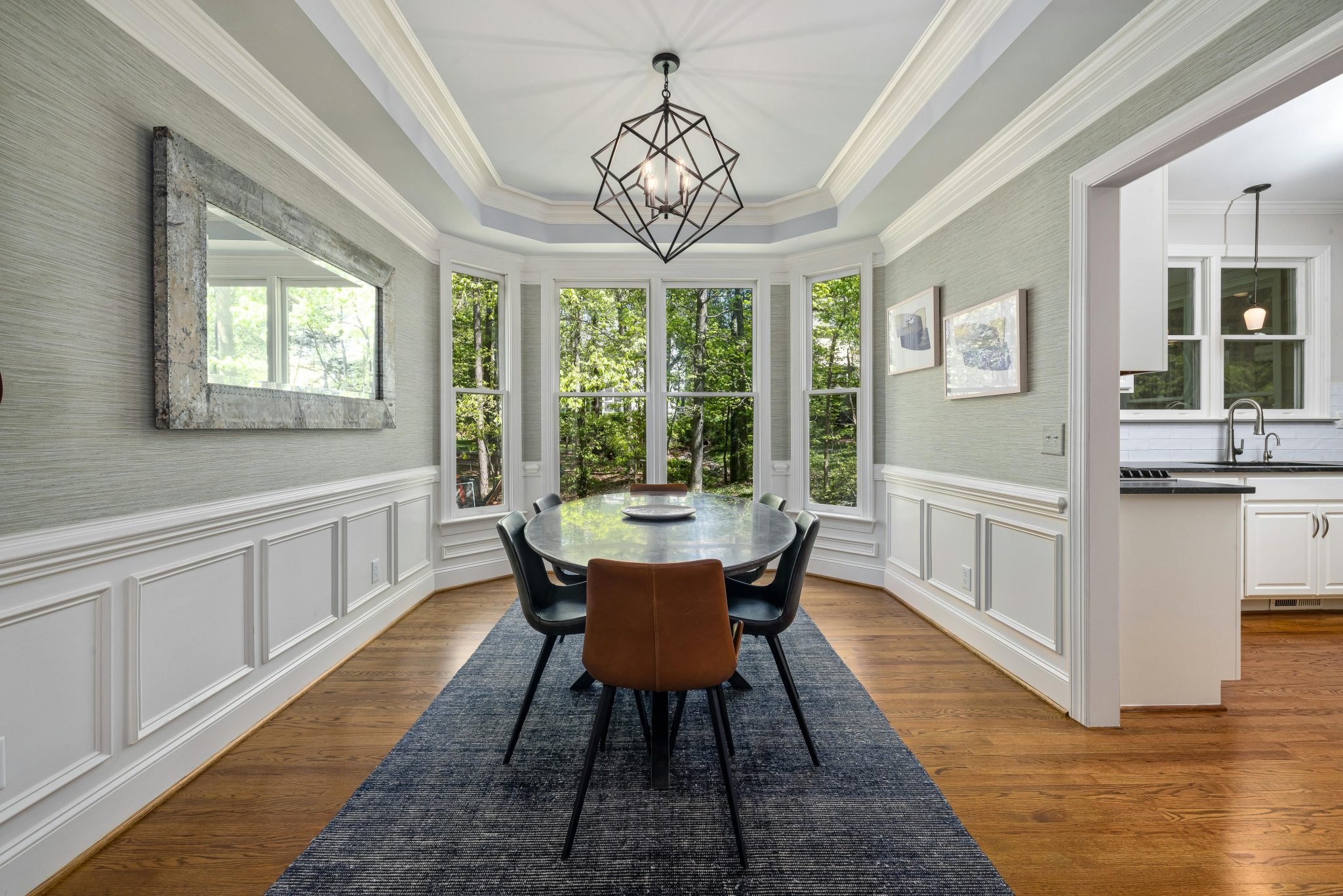 Elegant dining room featuring a stylish table, chairs, and large windows with natural light.