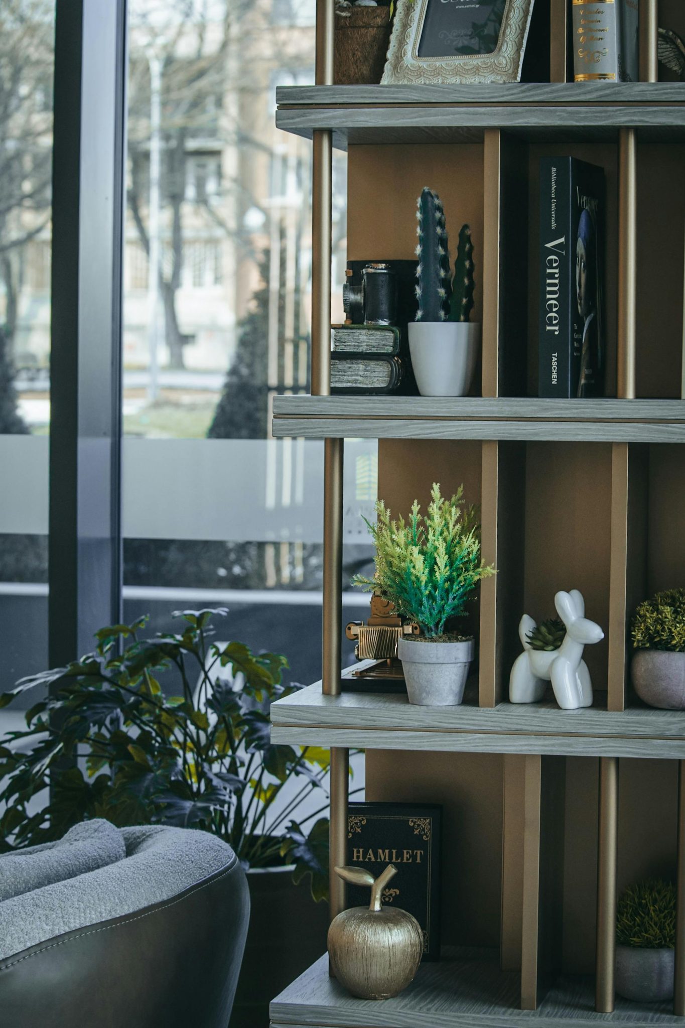 Elegant home interior featuring a decorative shelf with books, plants, and ornaments.