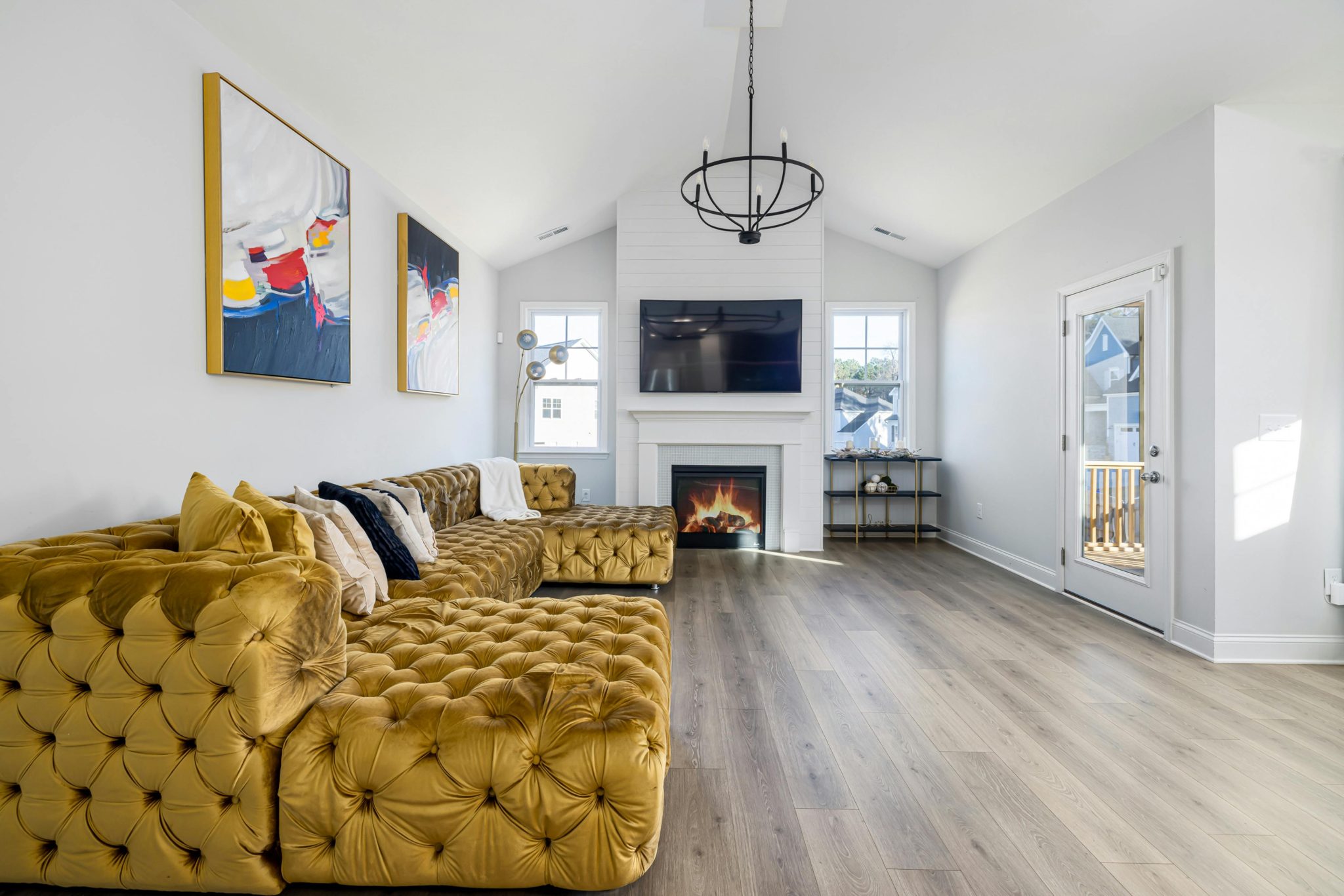 Elegant living room featuring a mustard tufted sofa, modern art, and a cozy fireplace.