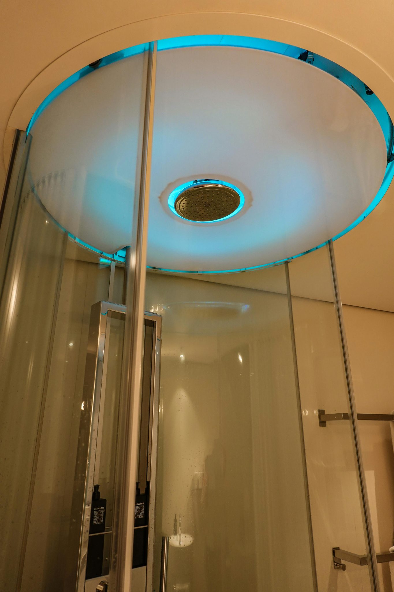 Elegant modern shower with chrome accents and ambient blue lighting.