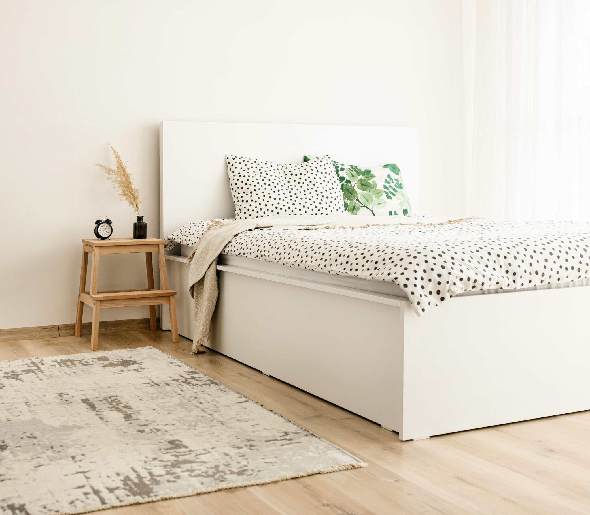 Elegant scandinavian-style bedroom with polka dot bedding and natural decor elements.