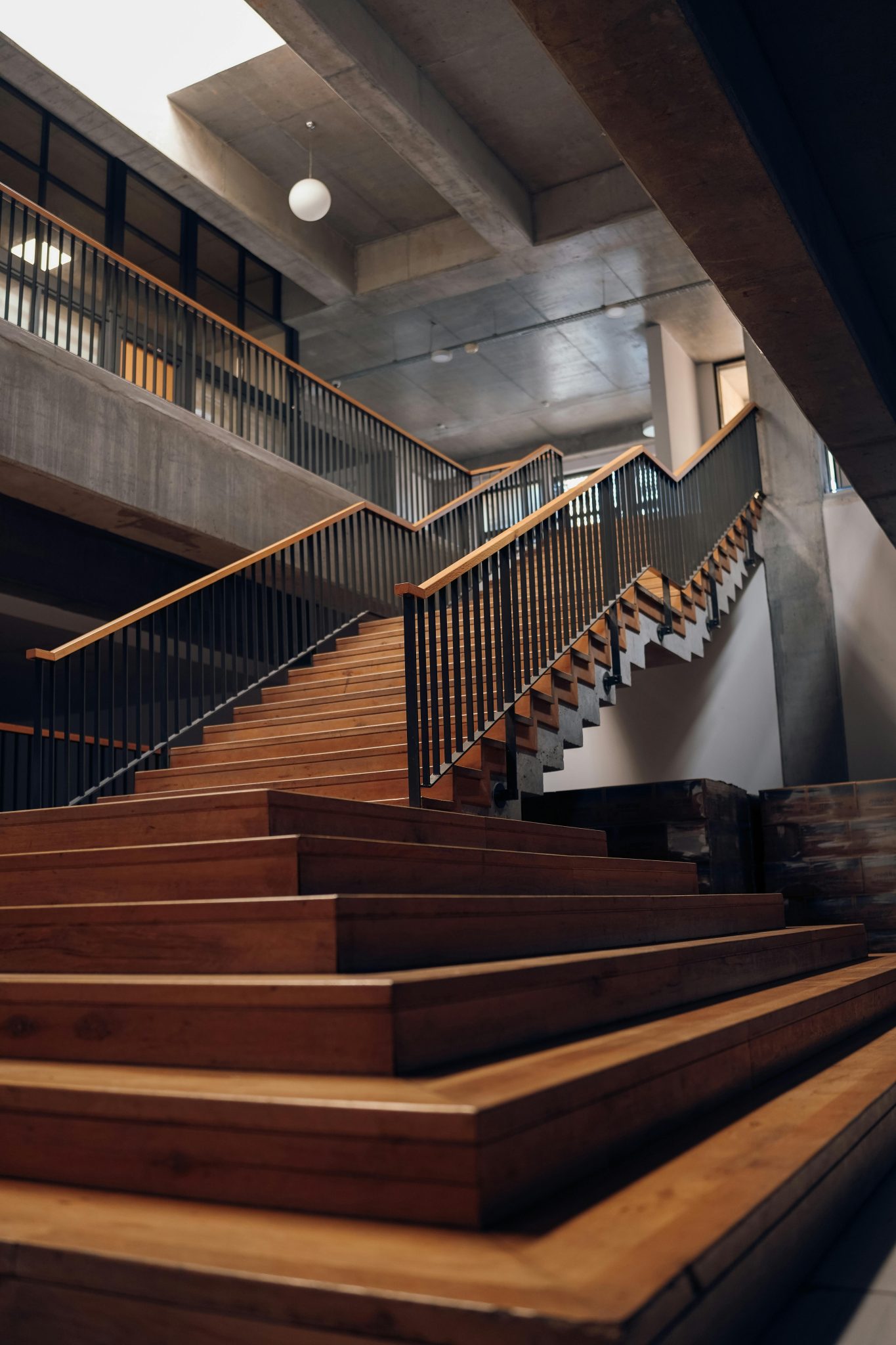 Elegant wooden staircase with sleek handrails in a modern interior setting.