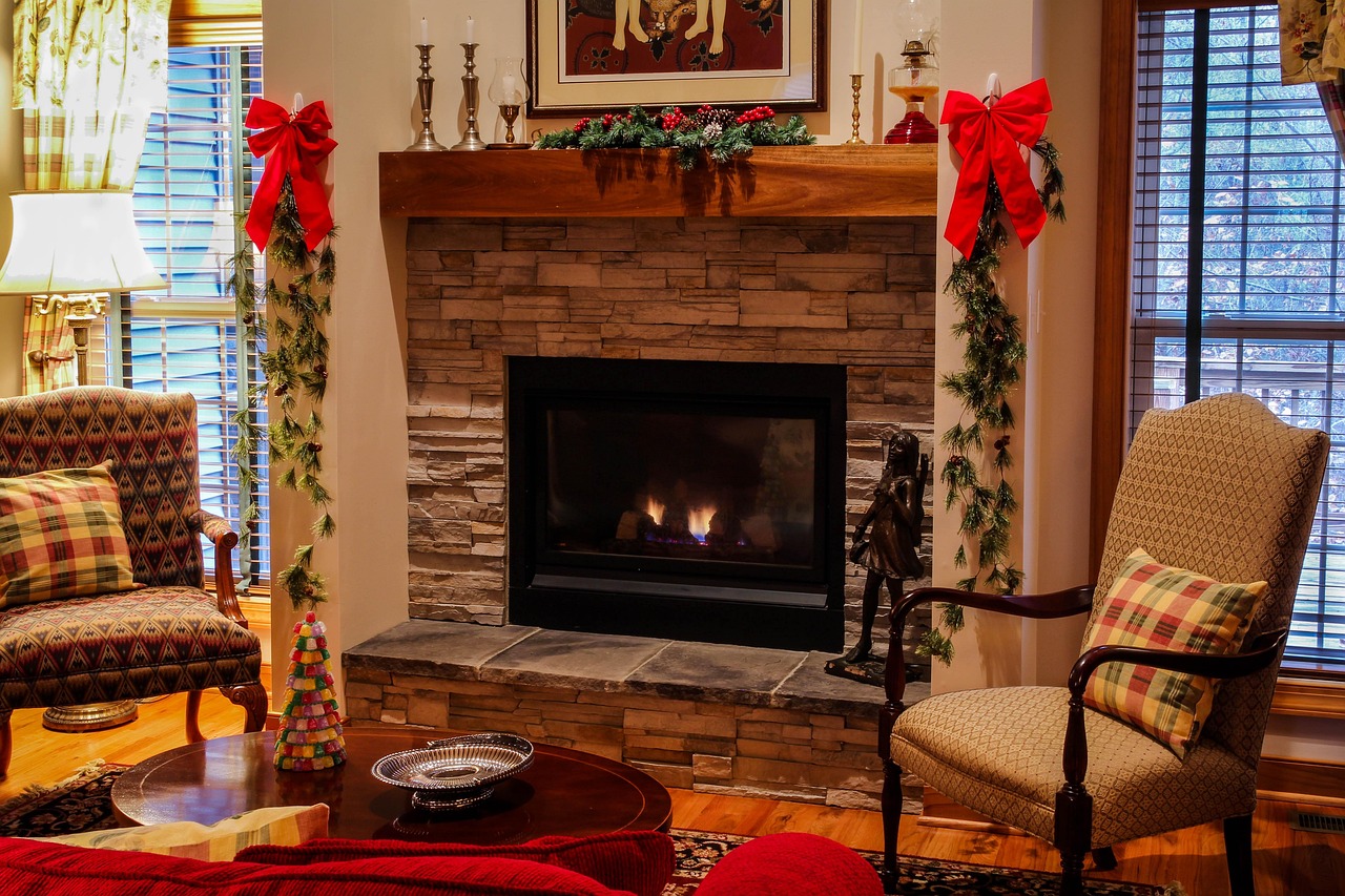 fireplace, mantel, living room, cozy, christmas, xmas, chairs, seating, stone fireplace, gas fireplace, hearth, family room, christmas decorations, red bows, pine garland, holiday decorations, coffee 