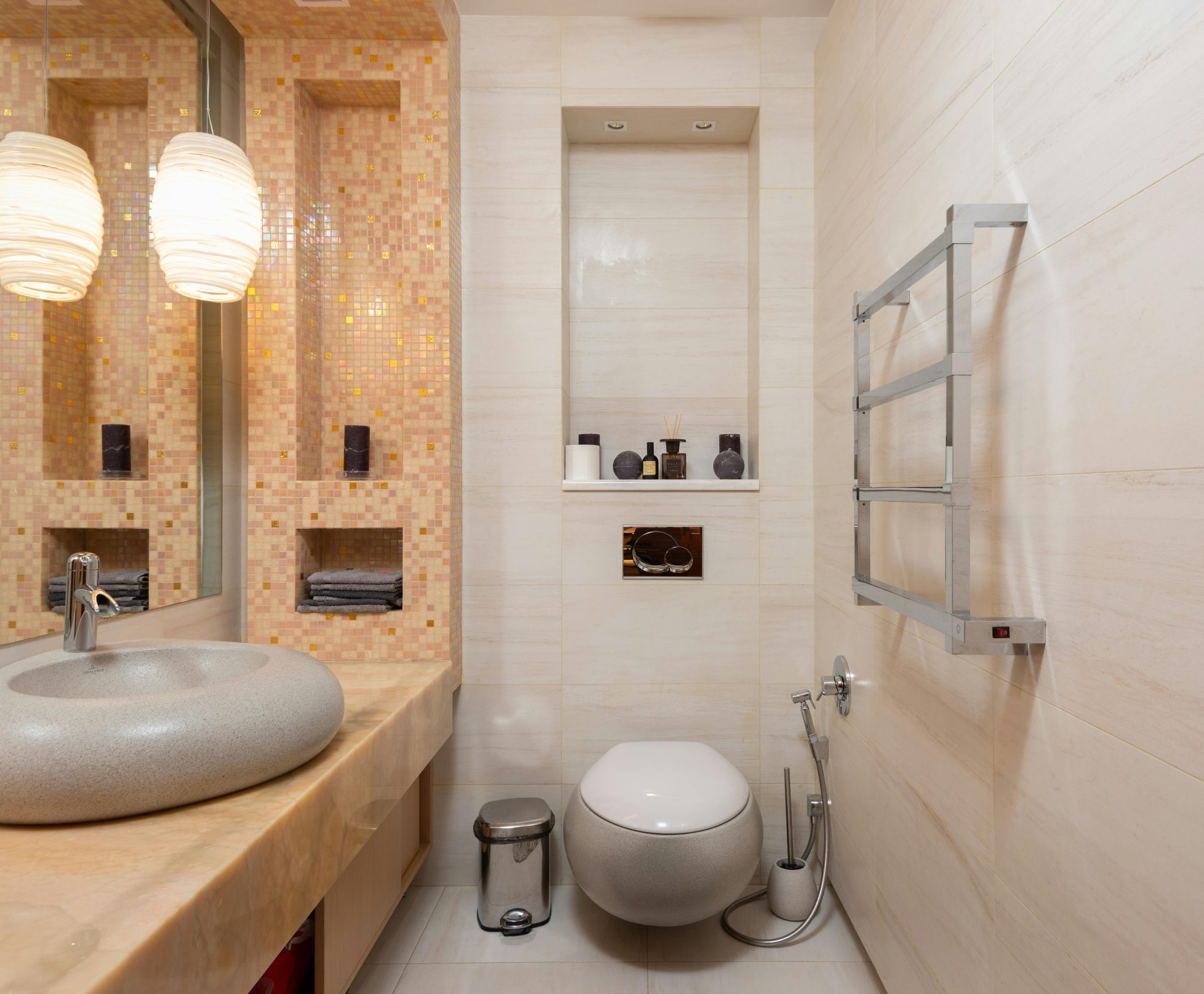 Interior of small light bathroom with ceramic sink and wall mounted toilet in modern apartment