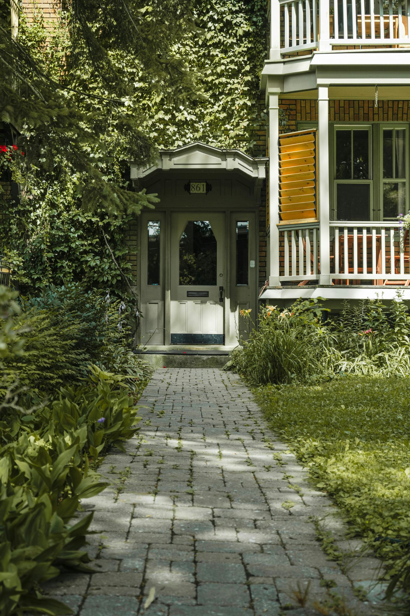 Inviting front door surrounded by lush greenery in a peaceful garden setting.